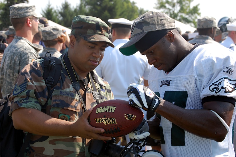 Philadelphia Eagles safety Quintin Mikell signs a football for Staff Sgt. Veuril McDavid of the U.S. Air Force Expeditionary Center, Fort Dix, N.J., during Military Day at the Eagles training camp Aug. 5, 2008, at Lehigh University in Lehigh, Penn.  More than 200 military members from all the services, including more than 50 Airmen from McGuire Air Force Base and Fort Dix, N.J., attended the event where they were served breakfast and held a meet and greet with Eagles staff and players.  (U.S. Air Force Photo/Tech. Sgt. Scott T. Sturkol)