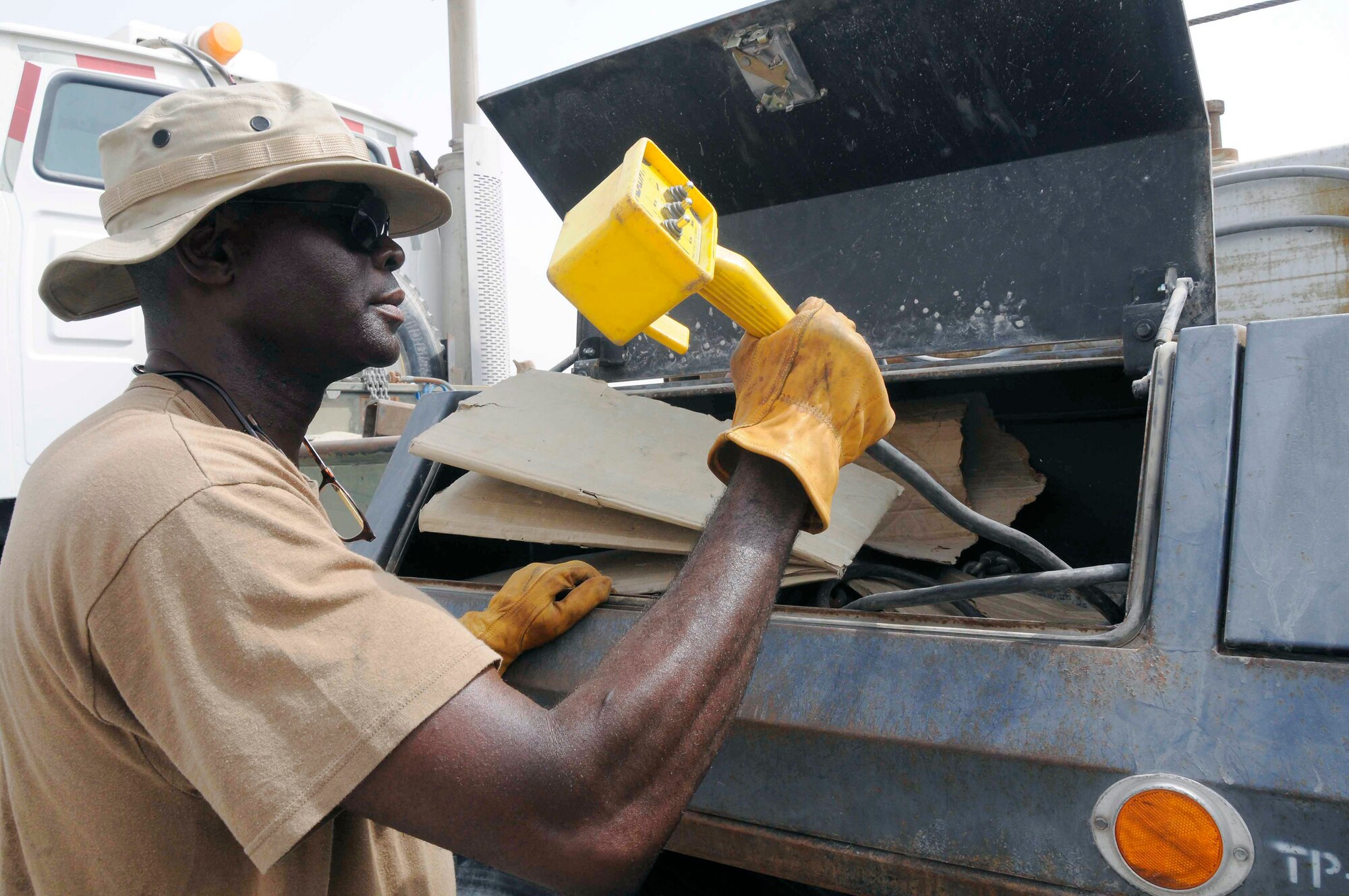 Mack Williams grabs the Zachlift remote control to lift a bus prior to towing July 22 at a Southwest Asian air base. Mr. Mack is a 379th Expeditionary Logistics Readiness Squadron vehicle operator trainer from Coolidge, Ga. (U.S. Air Force photo/Staff Sgt. Darnell T. Cannady) 
