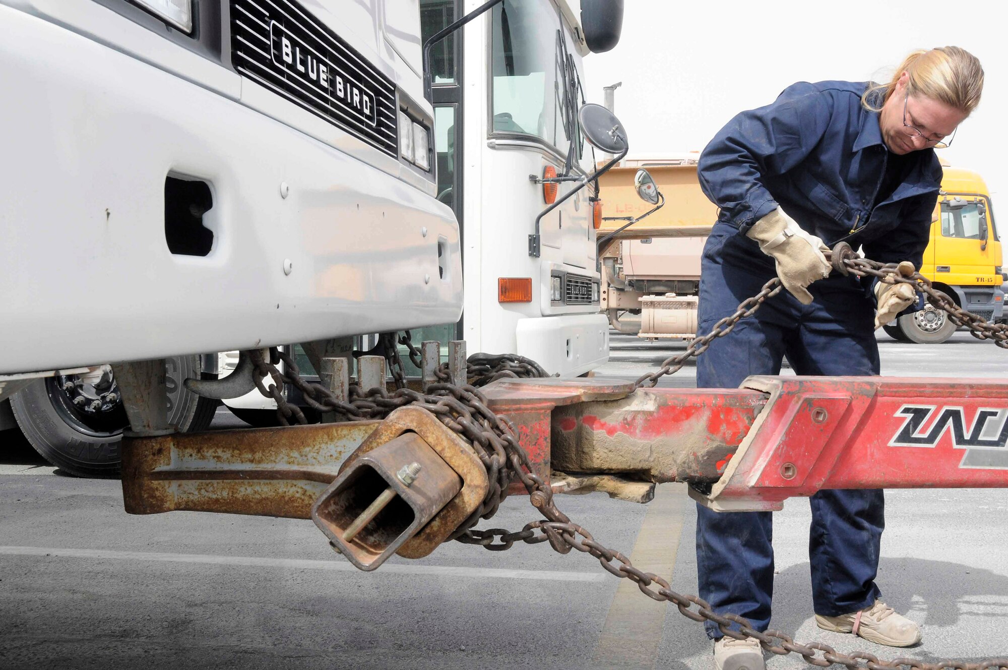 Gwen Crowder secures chains from a Zachlift to a bus July 22 at a Southwest Asian air base. Ms. Gwen is a 379th Expeditionary Logistics Readiness Squadron vehicle operator from Kileen, Texas. (U.S. Air Force photo/Staff Sgt. Darnell T. Cannady) 
