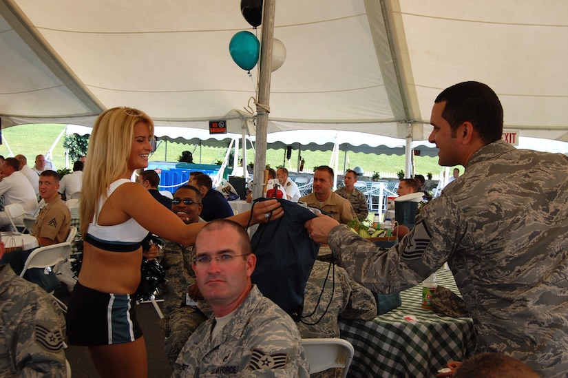 A Philadelphia Eagles cheerleader hands a door prize to a master sergeant from McGuire Air Force Base, N.J., during activities for Military Day at Philadelphia Eagles training camp in Lehigh University in Lehigh, Penn., Aug. 5, 2008.  More than 200 service members attended the event sponsored by the Eagles and the USO.  (U.S. Air Force Photo/Tech. Sgt. Scott T. Sturkol)