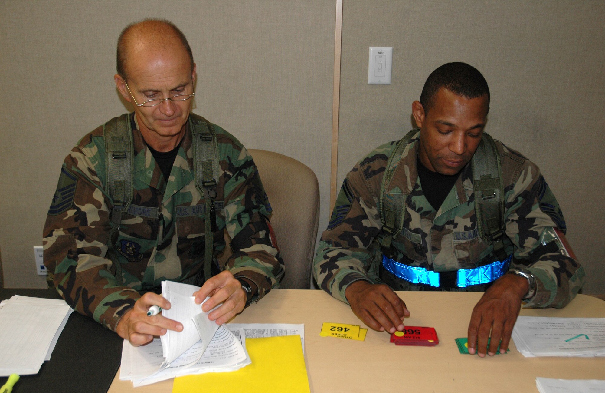 Senior Master Sgt. Dale Cotten and Master Sgt. Wayne Larrimore, both with the 512th Mission Support Group, outprocess Team Dover members Aug. 1 at the Combat Readiness Training Center, Alpena, Mich. More than 700 Airmen participated in the week-long operational readiness inspection. (U.S. Air Force photo/Capt. Marnee A.C. Losurdo)
