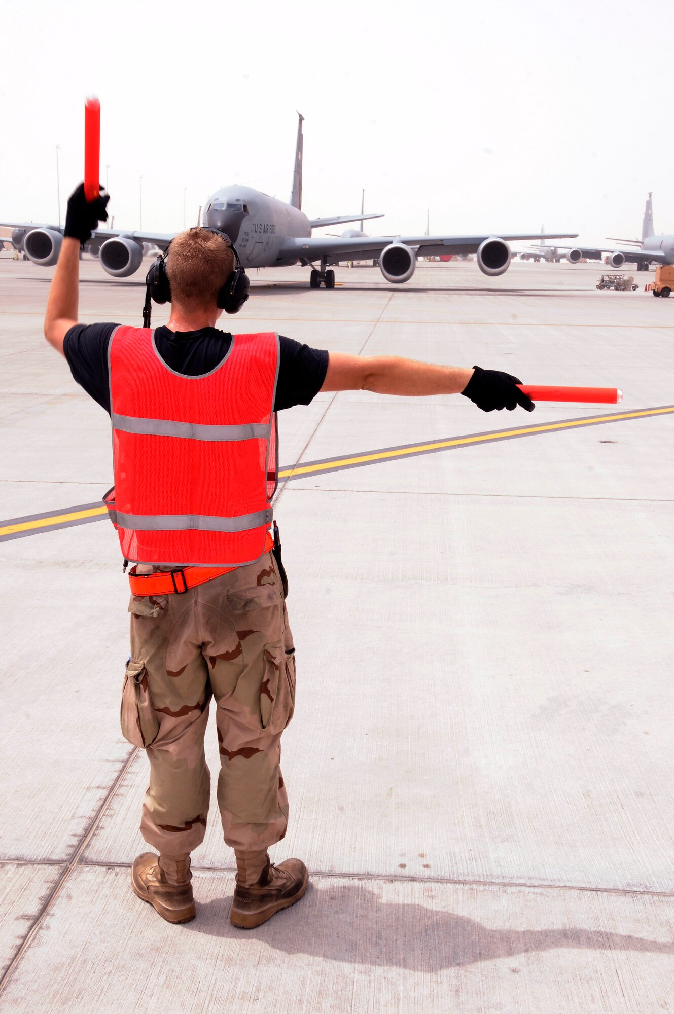 Airman 1st Class Derek Larue directs a turn for the KC-135 Stratotanker he is marshaling out of its parking spot Aug. 3 at a Southwest Asia air base. Members of the 340th Expeditionary Aircraft Maintenance Squadron refuel all types of bombers, fighters and other support aircraft engaged in perations Iraqi Freedom and Enduring Freedom and Combined Joint Task Force Horn of Africa. Airman Larue is assigned to the 340th EAXMS from Grand Forks Air Force Base, N.D. (U.S. Air Force photo/Tech. Sgt. Michael Boquette) 
