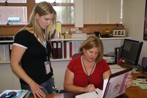 Lindsay Haig, an administrative assistant at AEDC White Oak in Maryland, listens as Lisa Schappacher, a management and program analyst at the facility, goes over revised security requirements for visitors. Haig, the most junior government employee at the facility, said she is considering going into public affairs as a result of her interactions with members of LabQuest, an alliance of local business owners, elected officials, economic development partners, and residents, who are supportive of the unique ground testing facility in their "backyard." Tunnel 9 Site Director Dan Marren said he chose her to represent the facility with the organization due to Haig's people skills. (Photo by Philip Lorenz III)