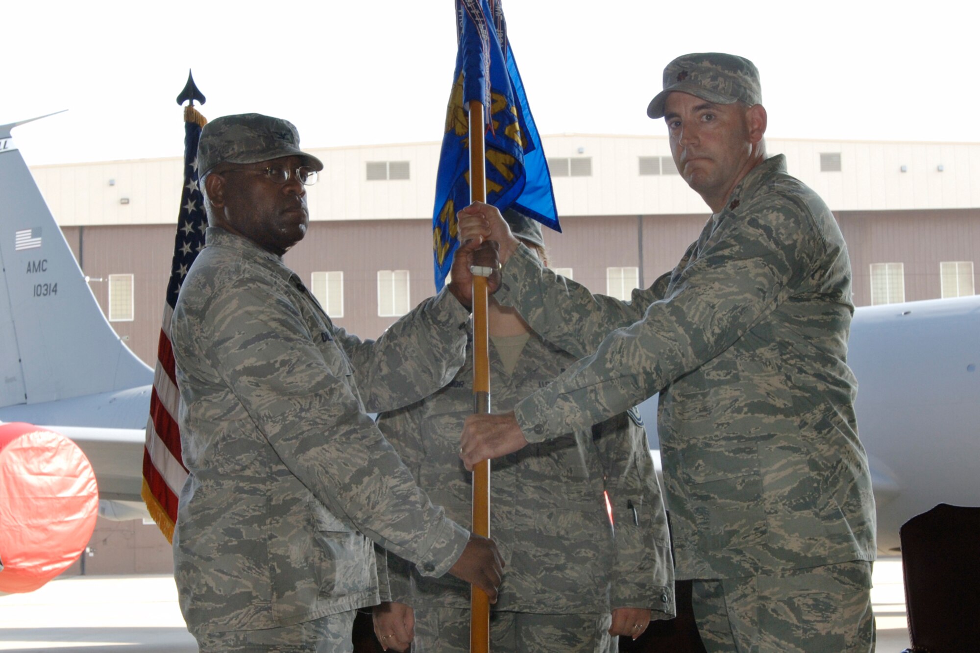 MCCONNELL AIR FORCE BASE, Kan. -- Col. Michael Dillard, left, officiates a change of command ceremony, Aug. 1, where he hands Maj. William Holt the squadron flag after taking command of the 22nd Aircraft Maintenance Squadron. (Photo by Staff Sgt. Jamie Train)