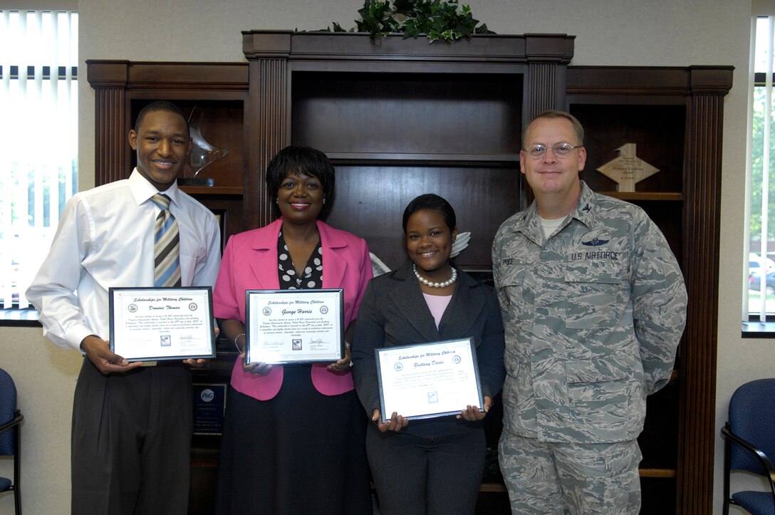 Dominic Thomas, Yuvonne Balentine-Harris (who is accepting for her son, George Harris) and Brittney Davis pose for a photo with Col. Stewart Price, 316th Mission Support Group commander, during a Defense Commissary scholarship presentation. An independent firm selected the winners from numerous essays that were submitted. (U.S. Air Force photo by Senior Airman Renae Kleckner)
