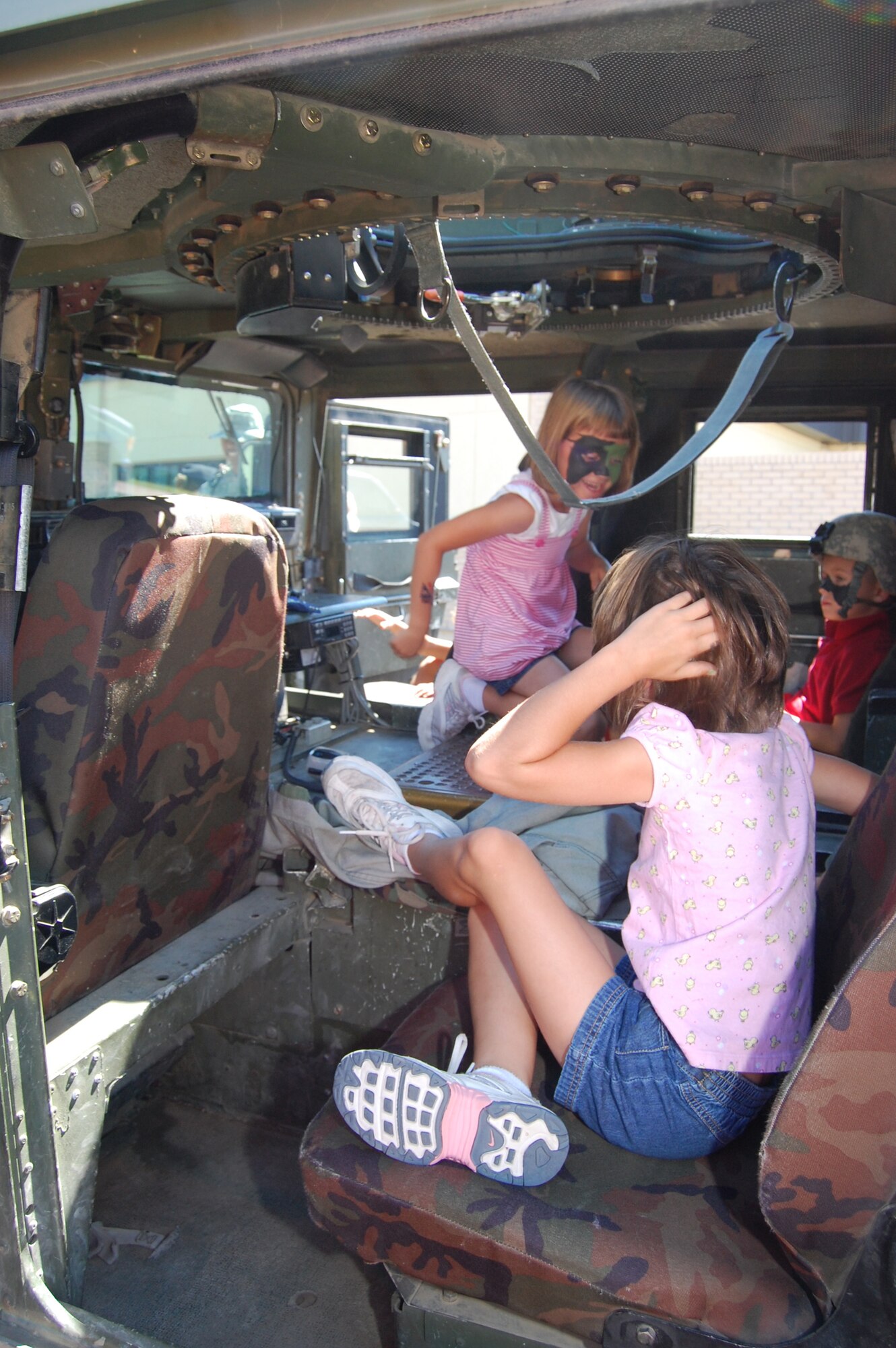 Little Warriors explore the inside of a Humvee during the Youth Programs Center's Be Our Guest mock deployment line Aug. 5. (U.S. Air Force photo/Airman 1st Class Emerald Ralston)
