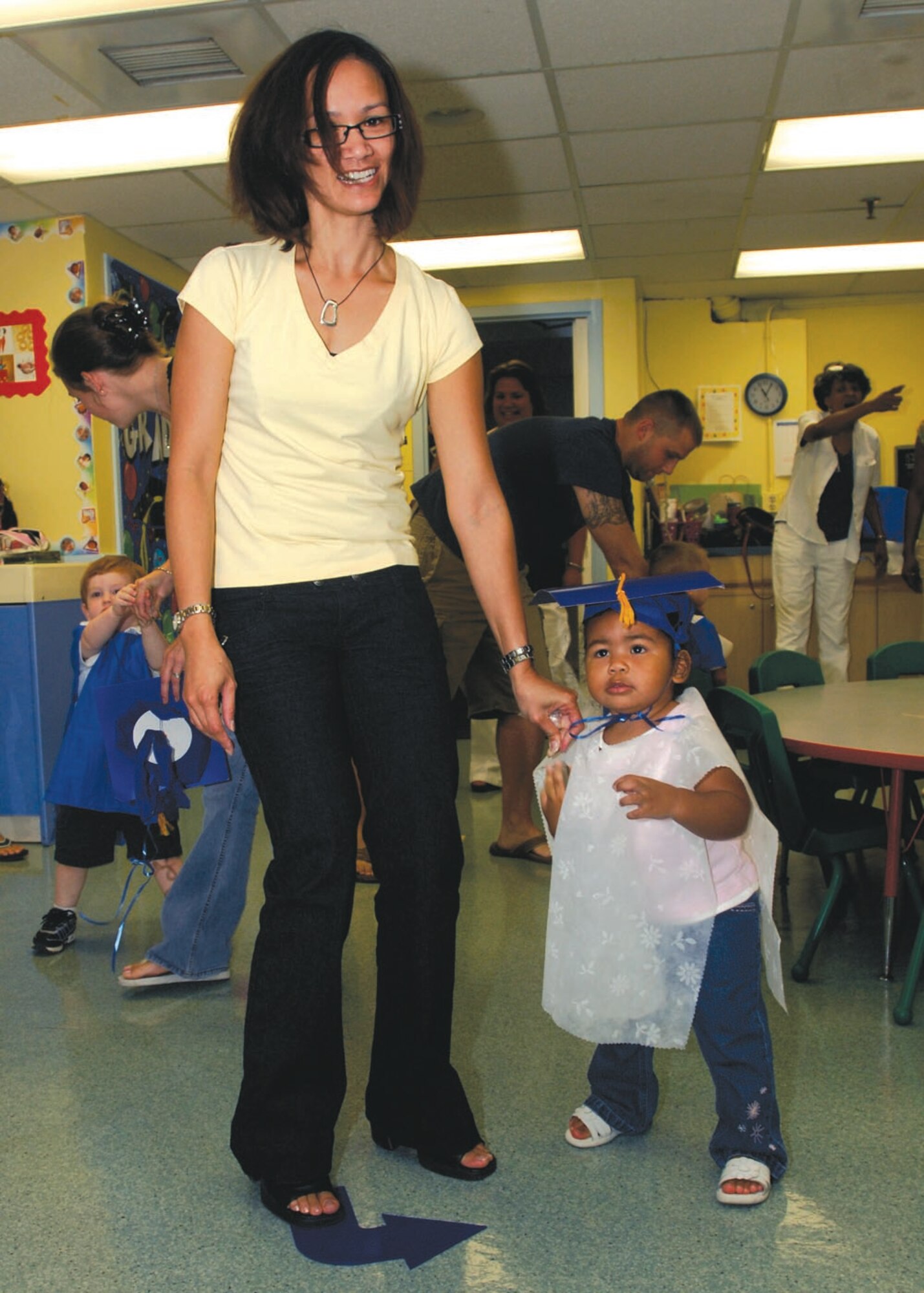 Rami Rice and daughter Jaiyana West, graduate of Infant University, parades around the room during the Infant-Toddler graduation on July 29 in Child Development Center 1. (U.S. Air Force photo by Senior Airman Melissa Stonecipher)