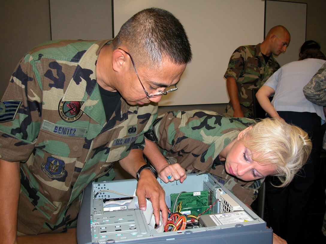 GRISSOM AIR RESERVE BASE, Ind., -- Tech. Sgt. Roland Benitez and Staff Sgt. Constance Chapman, both from the 434th Services Flight, take a close look at a computer during a information specialist training class held during a recent unit training assembly.  The administrators received basic computer hardware training and a hands-on familiarization during their training. (U.S. Air Force photo/Staff Sgt. Chris Bolen) 