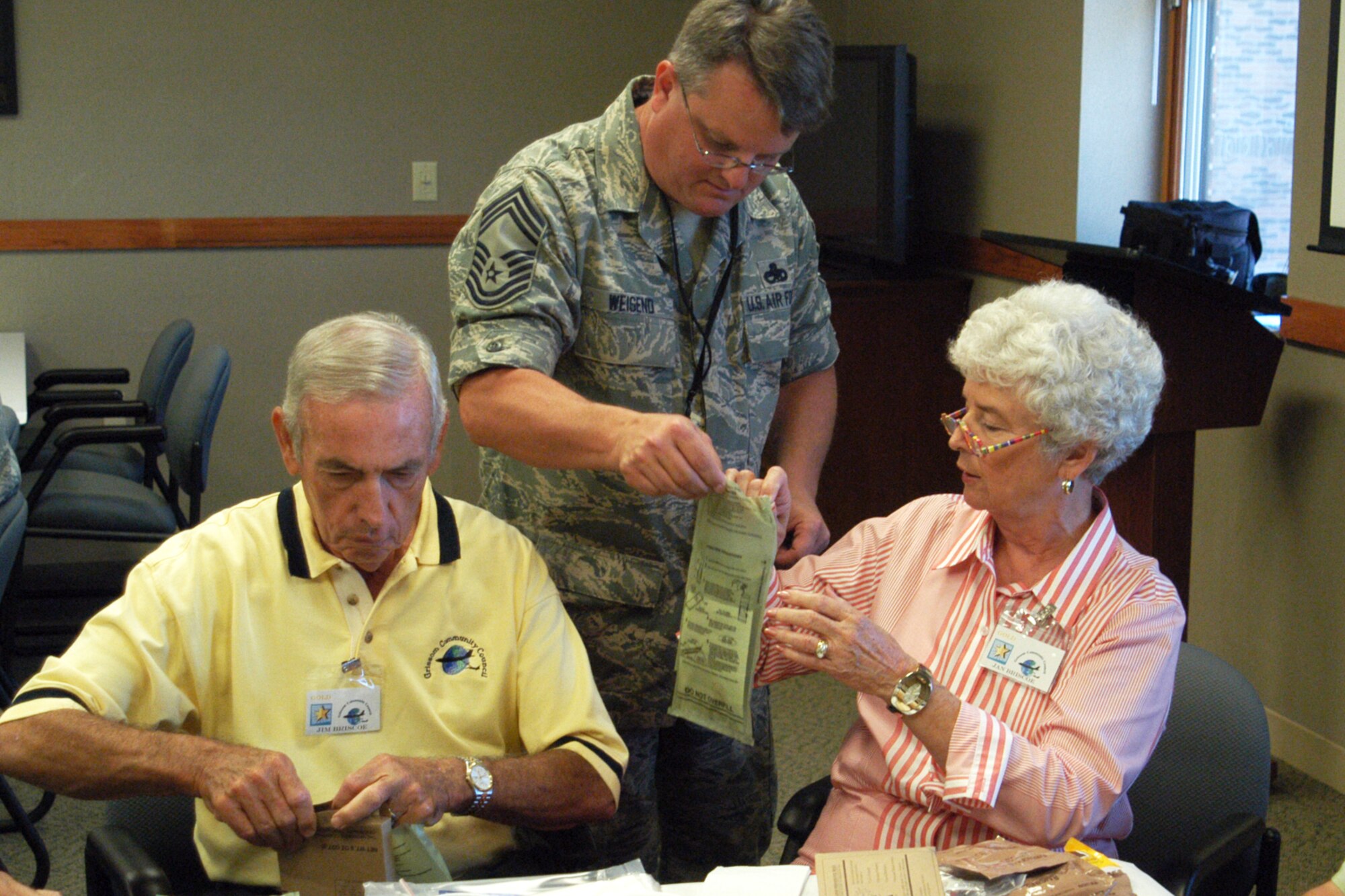 GRISSOM AIR RESERVE BASE, Ind., -- Chief Master Sgt. Chad Weisend, 434th Maintenance Group superintendent, assists Grissom Community Council member Jan Briscoe with her meal ready to eat -- or MRE, during a recent GCC visit to the base. On the far left is Jan's husband, and fellow GCC member, Jim Briscoe. During the visit, GCC members received a first-hand look at aircraft maintenance activities. (U.S. Air Force photo/Senior Airman Carl Berry)