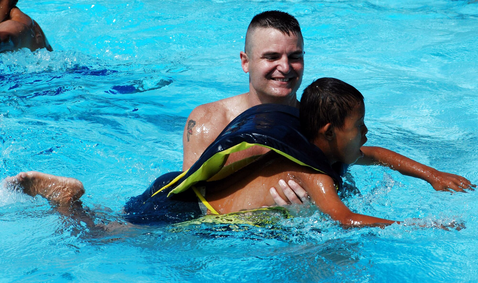 Capt. Dennis Spencer, a physician assistant with Joint Task Force-Bravo, plays with a child in the pool during a kids' day at Soto Cano Air Base, Honduras. More than 50 boys from the Hogar de Ninos Nazareth Orphanage in Comayagua came to the base Aug. 2 for a day of fun and activities.  (U.S. Air Force photo)

