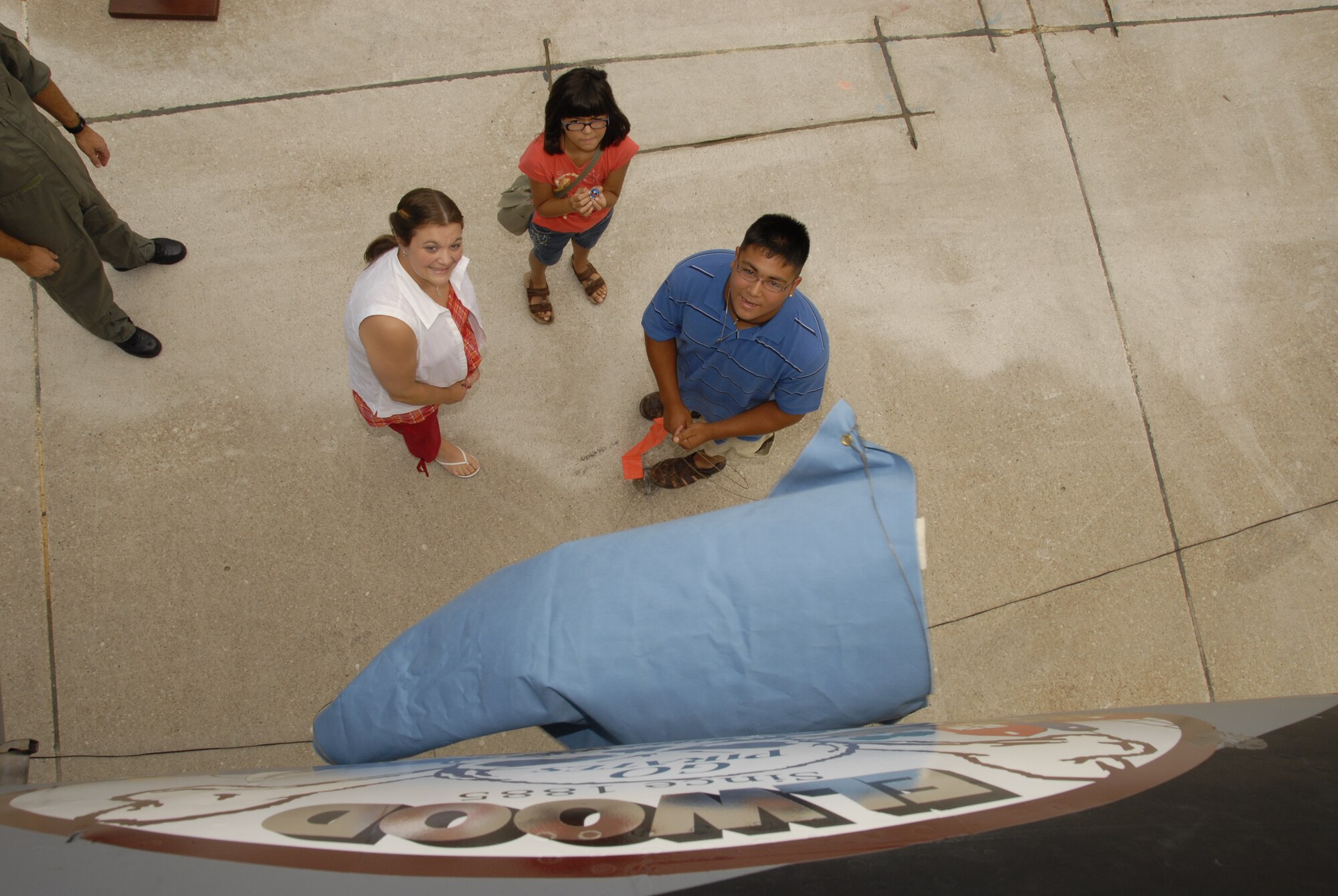 Brandon Randolph (right), with his mother Michelle Randolph (left) and sister Allisen Randolph, from Elwood, Neb.,unveils the winning nose art he designed for the 155th Air Refueling Wing, Nebraska Air National Guard nose art contest on Aug. 6, 2008 at the Nebraska Air National Guard Base, Lincoln, Neb.  The Nose Art program is a Community outreach program designed by the 155th Air Refueling Wing to promote the Air National Guard to the surrounding communities in Nebraska and to support the Nebraska Air National Guard members that hail from these communities. (Nebraska Air National Guard photo by Senior Master Sgt. Lee Straube)(Released)