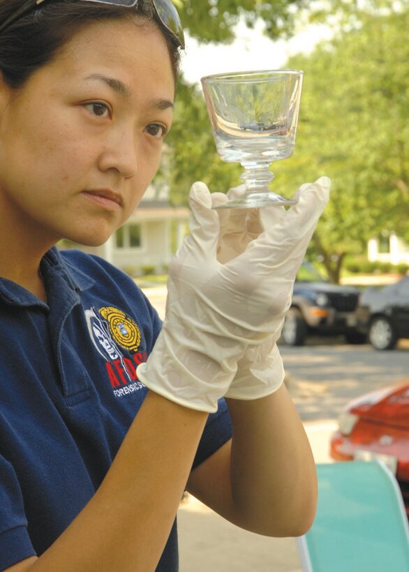 Special Agent Martha Ward, Forensic Science Consultant, 2nd Field Investigations Squadron, AFOSI Region 7, looks for fingerprints on a piece evidence used during a recent training exercise on-base July 17. (U.S. Air Force photo by Airman 1st Class Melissa Rodrigues)