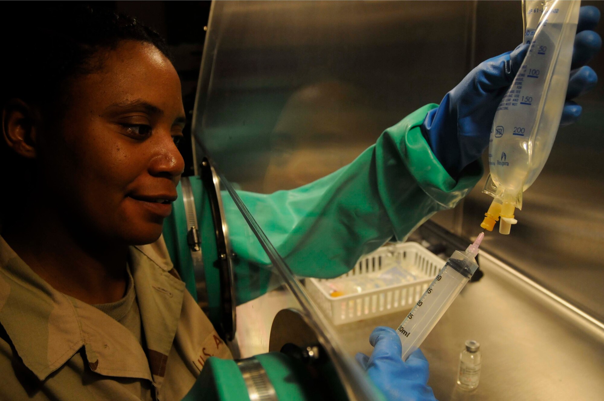 Staff Sgt. Tanisha Daniels, a pharmacy technician for the 379th Expeditionary Medical Group, injects vancomycin into an intravenous fluid bag for patients Aug. 7, 2008, at an undisclosed location in Southwest Asia. Sergeant Daniels prepares the IV bag inside of a hood to ensure the bag doesn't get any outside bacteria in it. Sergeant Daniels, a native of Greenville, N.C., is deployed from Keesler Air Force Base, Miss., in support of Operations Iraqi Freedom and Enduring Freedom. (U.S. Air Force photo by Staff Sgt. Darnell T. Cannady/RELEASED)