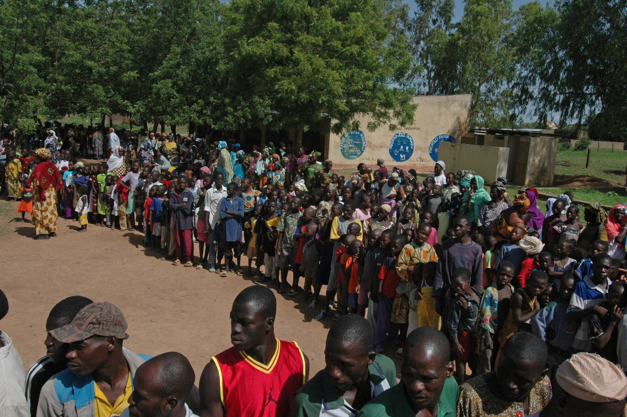Hundreds of Malians line up to be seen by American servicemembers July 24 in a village outside of Bamako, Mali. Throughout the medical training exercise, the American medical team visited four villages, trained more than 160 doctors, medics and nurses, saw more than 4,000 patients, extracted about 600 teeth, treated 4,100 goats and sheep, and conducted a mass casualty exercise in Mali. (U.S. Air Force photo/Senior Airman Justin Weaver) 
