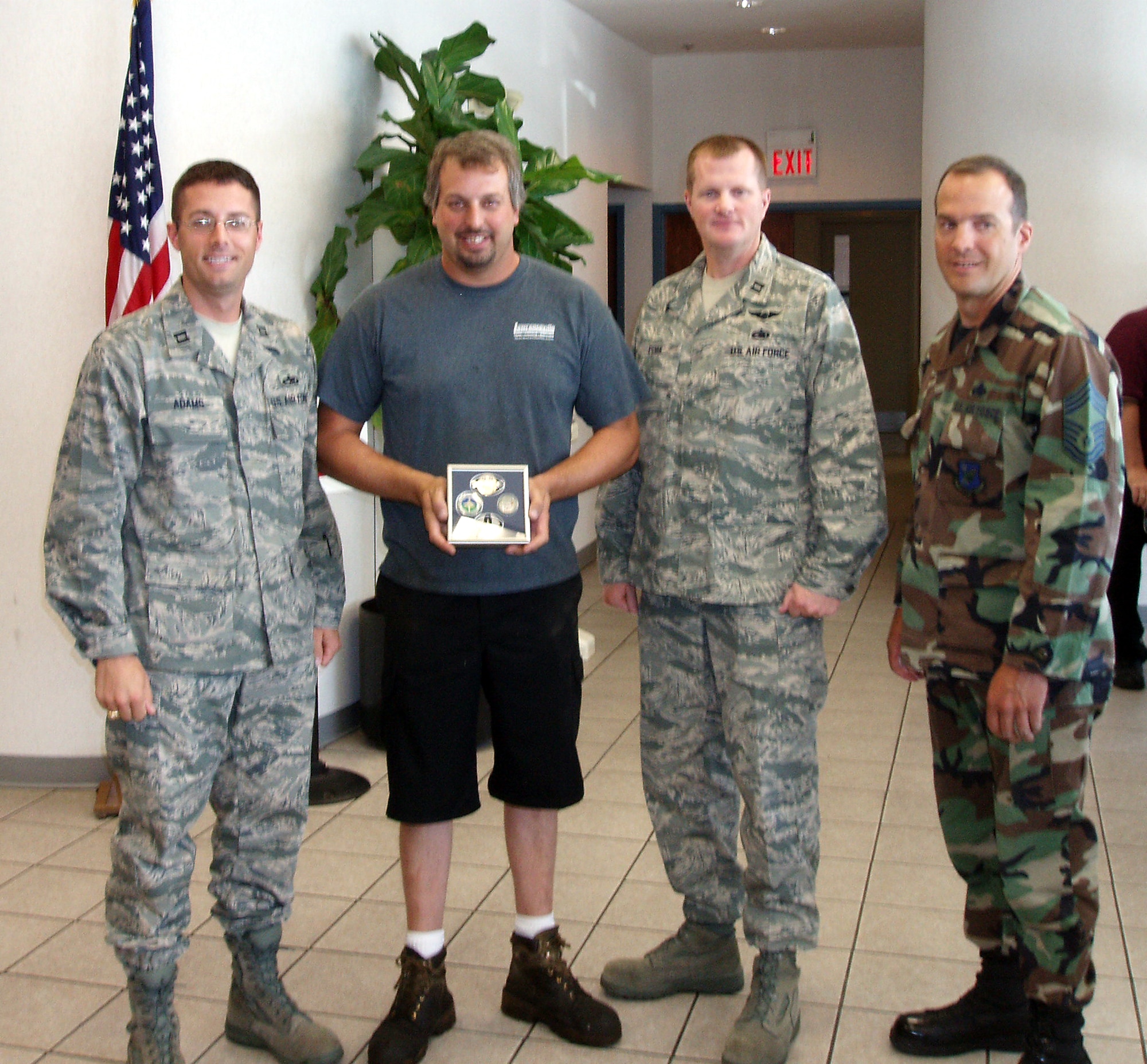 Left to right, Capt. Wes Adams, 605th Aircraft Maintenance Squadron, Don Cowan, fisherman, Capt. Jim Dorn, 305th Maintenance Group, and Chief Master Sgt. Dan Romano, 605th AMXS after presenting Captain Don with coins from each of their squadrons and one from the 305th MXG for outstanding performance. Captain Don offers free guided fishing trips to show his appreciation and support to the U.S. military. (U.S. Air Force courtesy photo) 