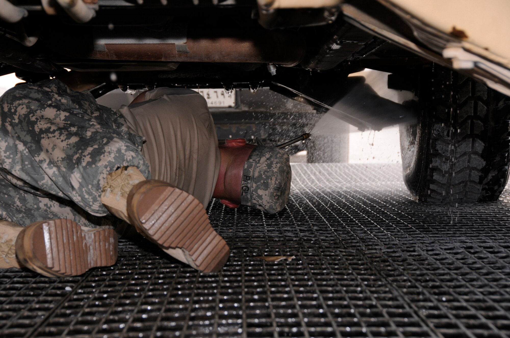 Pfc. Kevin Page, A 2-43, Air Defense Artillery from Fort Bliss, Texas, uses a high pressure water hose to clean the undercarriage of a Battery Command Post (BCP) vehicle Aug. 7, 2008.  The soldiers are cleaning the BCP in preparation for shipping it back to Texas from an undisclosed airbase in Southwest Asia.  (U.S. Air Force photo by Tech. Sgt. Michael Boquette/RELEASED)