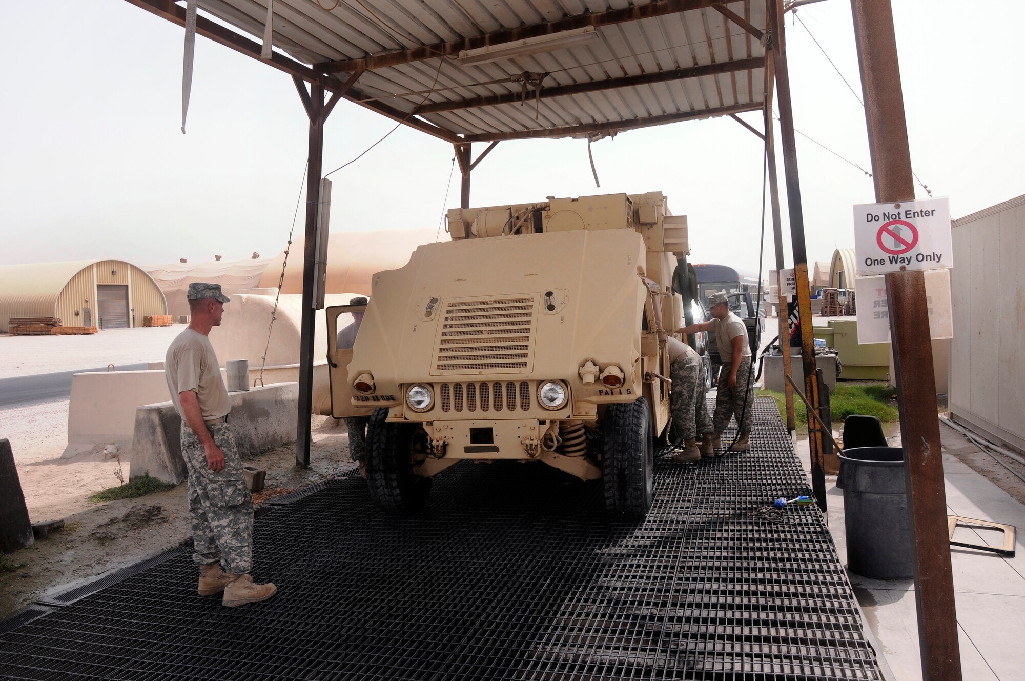 Soldiers deployed from the A 2-43, Air Defense Artillery at Fort Bliss, Texas, use a high pressure water hose to clean up a Battery Command Post (BCP) vehicle Aug. 7, 2008.  The soldiers are cleaning the BCP in preparation for shipping it back to Texas from an undisclosed airbase in Southwest Asia.  (U.S. Air Force photo by Tech. Sgt. Michael Boquette/RELEASED)