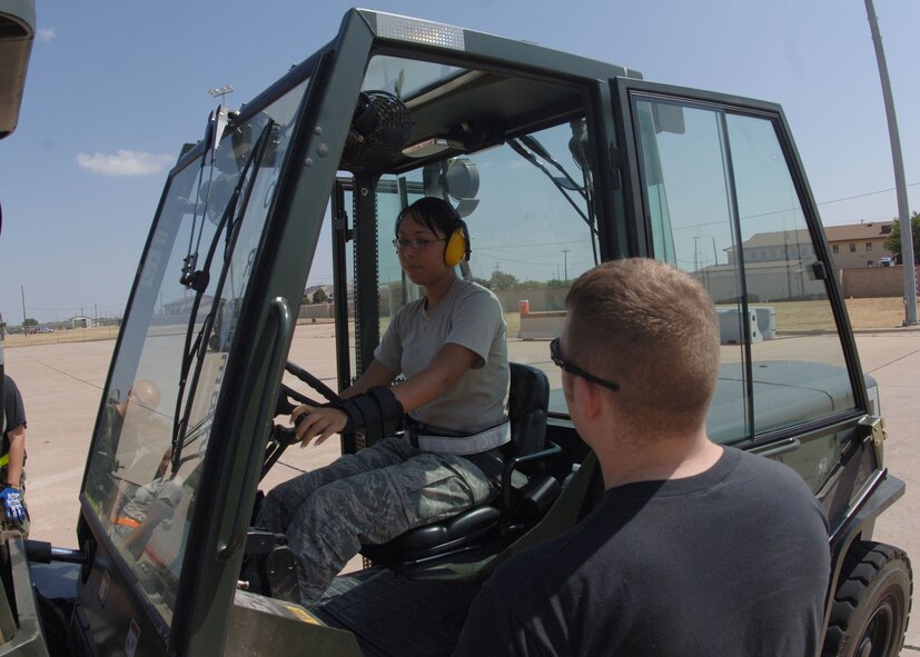 DYESS AIR FORCE BASE, TEXAS -- Staff Sgt. Michael Botti instructs Senior Airman Noel Brown on where to place a cargo palette during the Cargo Rodeo, July 30. During Cargo Rodeos, forklift operations are common. Due to the heavy nature of the cargo being transported, the rodeo is somewhat dangerous and Airmen must practice good risk management. (U.S. Air Force Photo by Airman 1st Class Micheal Breaux).
