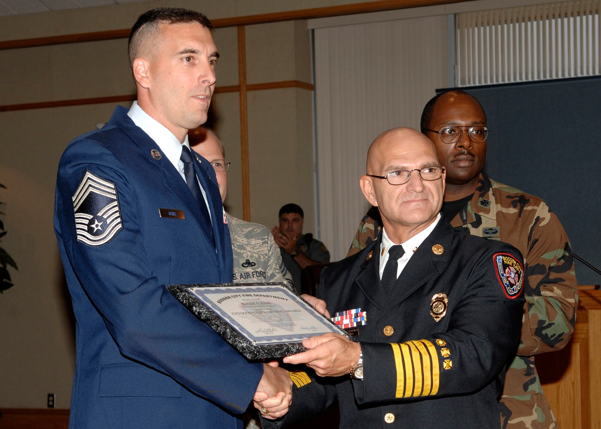 BARKSDALE AIR FORCE BASE, La -- Chief Master Sgt. Ronald Gisel, 2d Communications Squadron, was awarded Bossier City Fire Department's Citizen's Lifesaving Award by Fire Chief Sammy Halphen for his heroic acts during a city council meeting Tuesday. (U.S. Air Force photo by Airman 1st Class Brittany Y.Bateman)(RELEASED) 