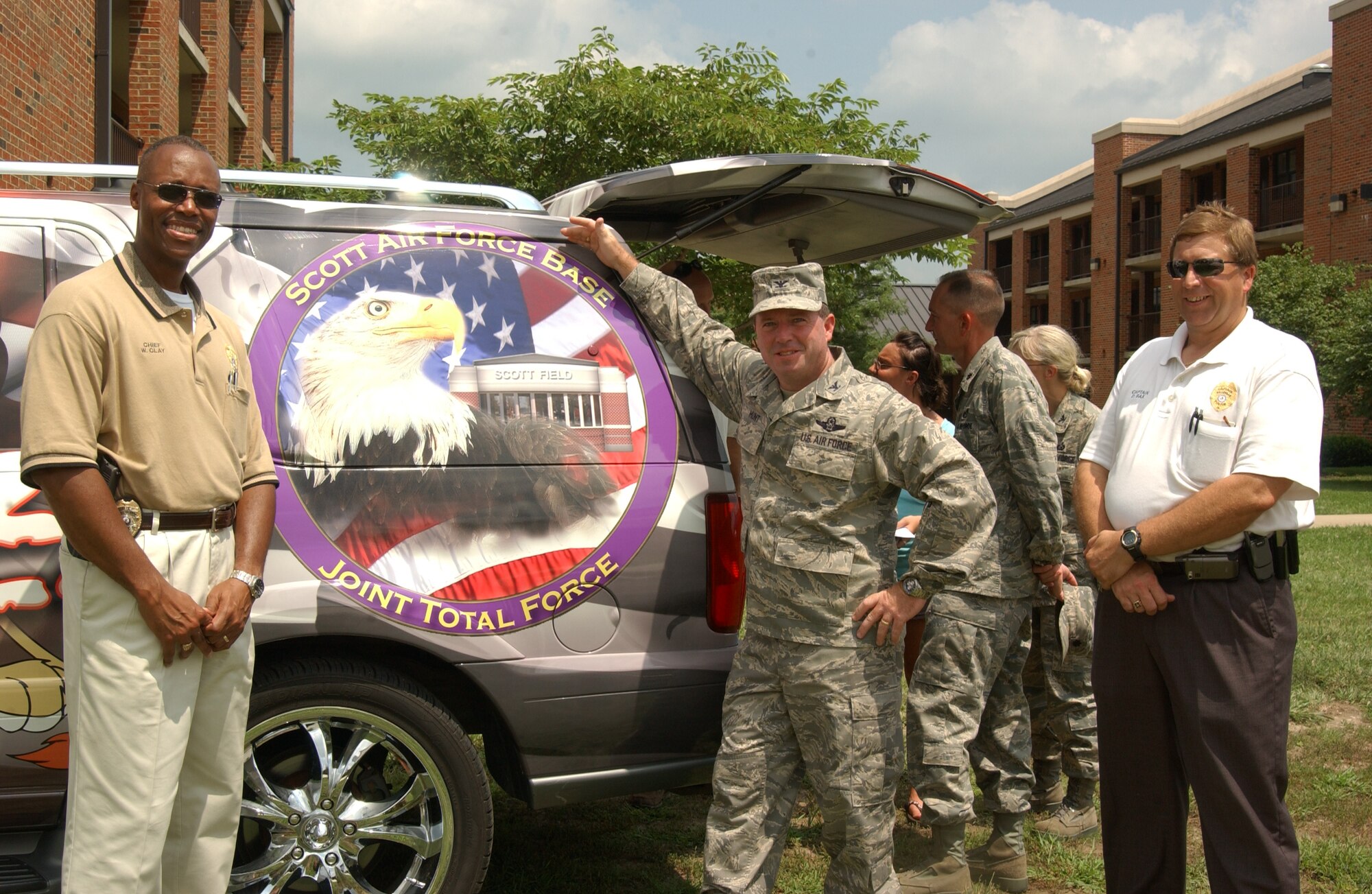 Col. Al Hunt, (right) 375th Airlift Wing commander, stands with Belleville Police Chief Bill Clay in front of their newest D.A.R.E. vehicle with a pointed coin on it. 
(U.S. Air Force Photo by Airman 1st Class Amber Kelly-Woodward)