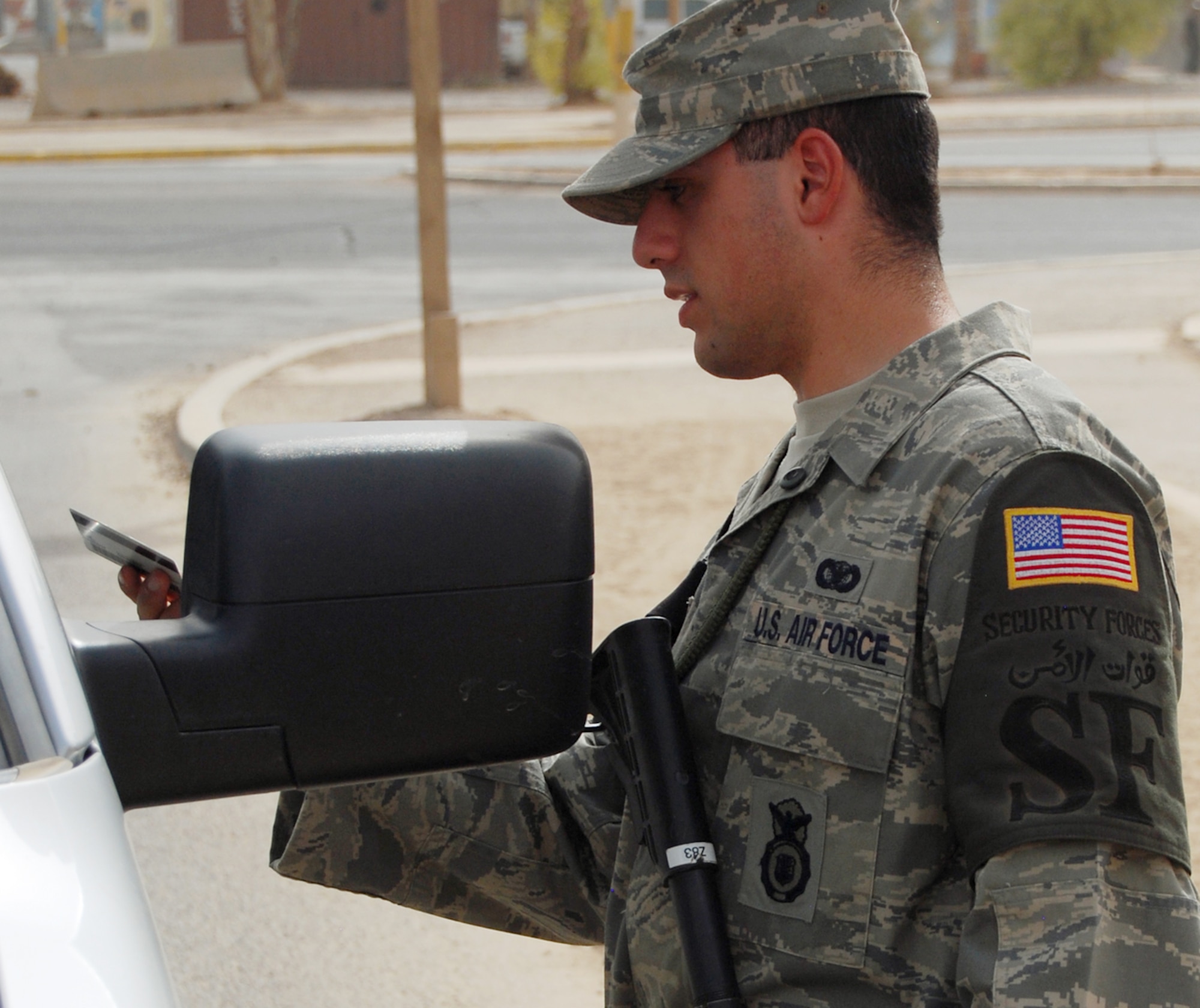 JOINT BASE BALAD, Iraq -- Airman 1st Class Murad Mohiadeen checks the ID of a vehicle operator at an entry control point to the Air Force Theater Hospital here Aug. 2. Airman Mohiadeen, a native of Baghdad, was raised in the United States after his family emigrated from Iraq in 1990. Airman Mohiadeen is a security forces apprentice with the 332nd Expeditionary Security Forces Squadron and is deployed from Royal Air Force Lakenheath, England. (U.S. Air Force photo/Staff Sgt. Don Branum)