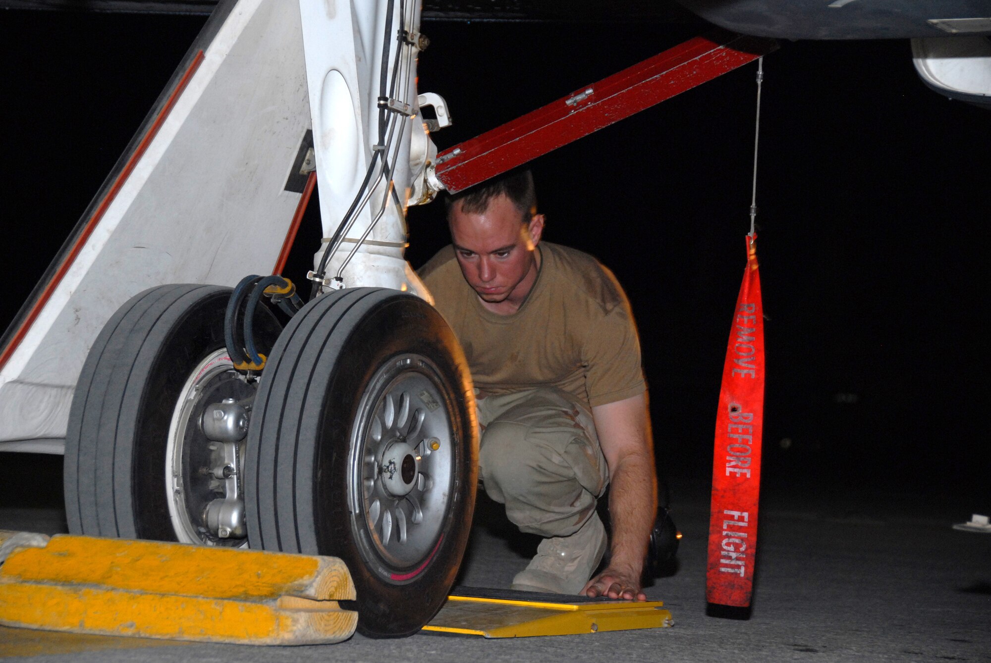 SOUTHWEST ASIA--Senior Airman James Goode, a member of the 380th Expeditionary Aircraft Maintenance Squadron, positions a scale during recovery of a Global Hawk aircraft. The Global Hawk is an unmanned aerial vehicle that is being used for Operation Enduring and Iraqi Freedom. Airman Goode is deployed from the 9th Aircraft Maintenance Squadron out of Beale Air Force Base, Calif., his hometown is Winchester, Va.(U.S. Air Force photo/Tech. Sgt. Christopher A Campbell)(released)
