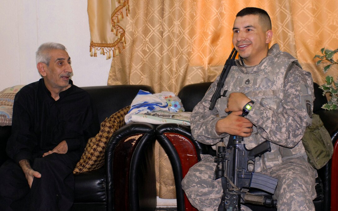 Army Staff Sgt. Aaron Baeza, left, of Odessa, Texas, a patrol leader with Task Force Vigilant, interacts with an Iraqi man during a household assessment in southern Baghdad on Aug. 1, 2008. U.S. Army photo by Staff Sgt. Michel Sauret, Multinational Division Center