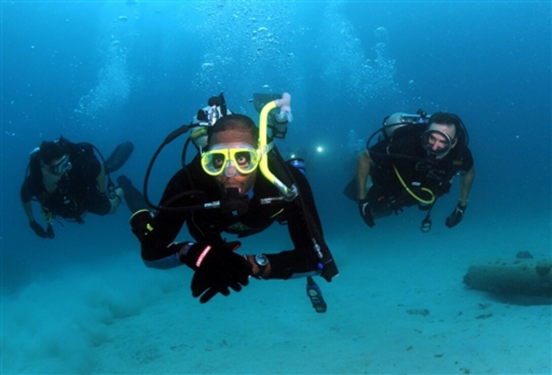 Barbados Coast Guard Petty Officer Ricky Howell, swims with Rear Adm. Joseph D. Kernan, commanding officer of U.S. Fourth Fleet, right, and Lt. Cmdr. Bobby Greene during a dive off the coast of Barbados during Navy Dive Southern Partnership Station  2008 in Bridgetown Harbor, Barbados, Aug. 5, 2008.