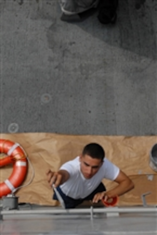 U.S. Navy Boatswain's Mate Seaman Armen Bakanyan reaches up to paint a pipe aboard the guided-missile destroyer USS Gridley (DDG 101) while underway in the Pacific Ocean on Aug. 5, 2008.  The Gridley is with the Ronald Reagan Carrier Strike Group and is on a deployment in the 7th Fleet area of responsibility.  