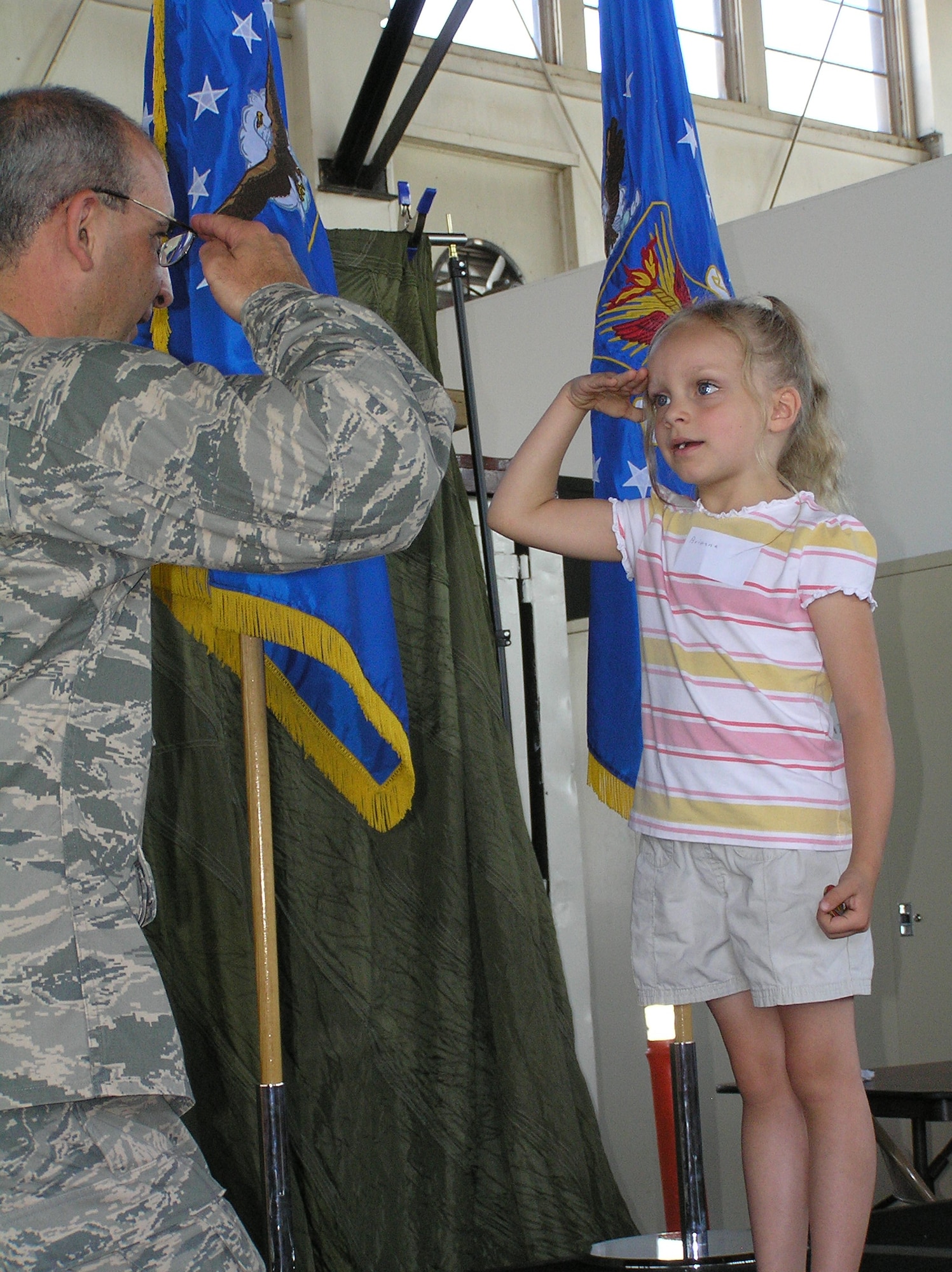 Col. James J. Muscatell, Jr., Commander of the 302nd Airlift Wing salutes Briana Taylor, daughter of Technical Sgt. Tye Taylor of the 302nd Maintenance Squadron, during the 302nd AW Key Family Member Program “Herc Adventure Tour of Duty.”  During the “Herc Adventure Tour of Duty” children of wing reservists had the opportunity to participate in special kid-friendly hands-on activities demonstrating what their reserve parents do during their reserve duties.  Activities included aviation, security, life support and recognition related demonstrations.  Col. Muscatell thanked each child in attendance for sharing their parents with the world during the shake, take and salute activity. (U.S. Air Force photo by Ann Skarban)
