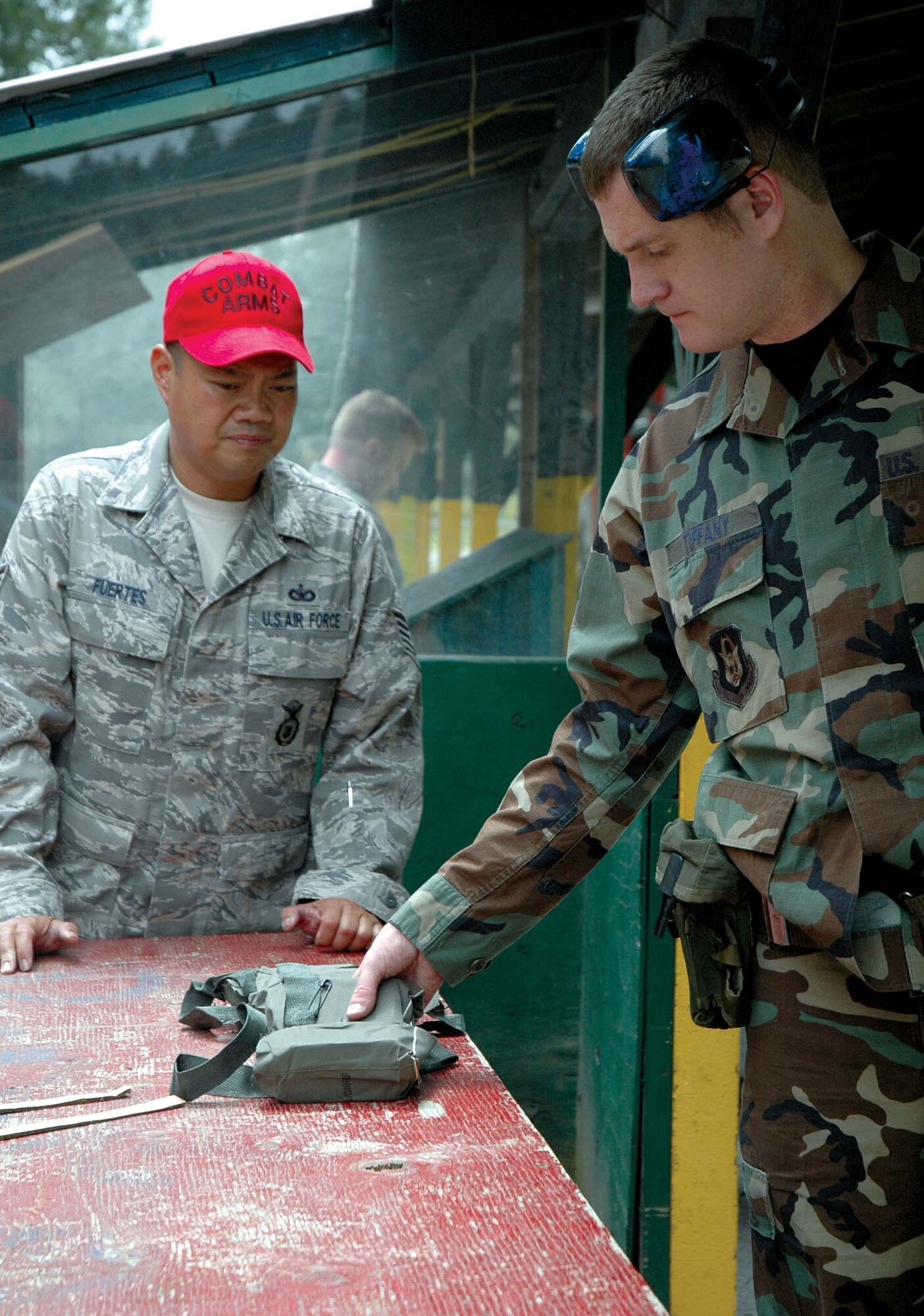 Tech. Sgt. John Fuertes, 446th Security Forces Squadron, (right) watches as Staff Sgt. Jake Tiffany, 446th Civil Engineer Squadron, grabs ammunition pouches for his M-16 rifle qualification. Sergeant Fuertes, along with other Combat Arms instructors ensure Airmen are properly supplied when they go out to the firing range. (U.S. Air Force photo/Senior Airman Desiree Kiliz)