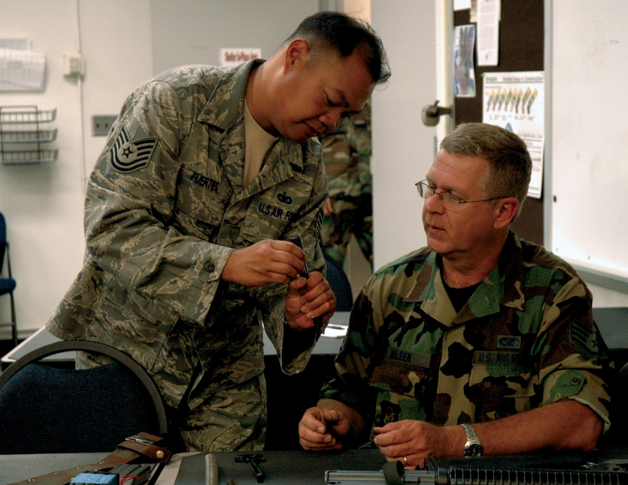 Combat Arms instructor Tech. Sgt. John Fuertes, 446th Security Forces Squadron, shows Staff Sgt. Anders Nilsen, 446th Civil Engineer Squadron, how to reassemble his M-16 rifle. Sergeant Fuertes and the other CATM instructors teach all 446th Airlift Wing Reservists weapons safety, assembly, firing and cleaning to ensure they are deployable. (U.S. Air Force photo/Senior Airman Desiree Kiliz)