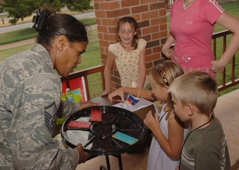 DYESS AIR FORCE BASE, Texas -- Master Sgt. Annette Collins hands out icing-covered graham crackers to children attending Vacation Bible School located at the Base Chapel here Aug. 6. Vacation Bible School is a time where children can learn about various books in the Bible as well as enjoy singing and worship. Dyess strives to provide, mental, physical, and spiritual programs to promote total mind and body health. (U.S. Air Force photo/Airman 1st Class Micheal Breaux).