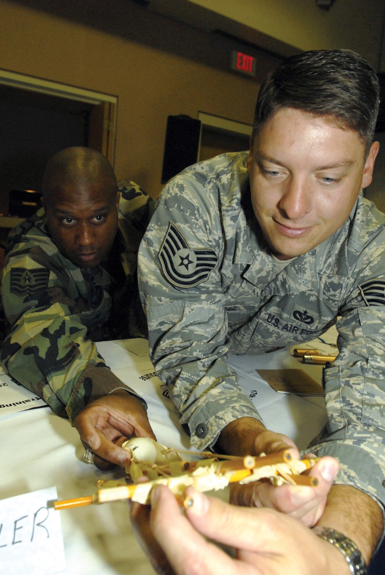 Technical Sergeamt Daryl Hogan (left) and Tech. Sgt. Jeffrey Kimball (right) test their miniaturized seige engine during "Junkyard Wars," a team-building exercise at the Senior NCO Orientation Course August 5. (U.S. Air Force photo by Master Sgt. Randy Mallard)