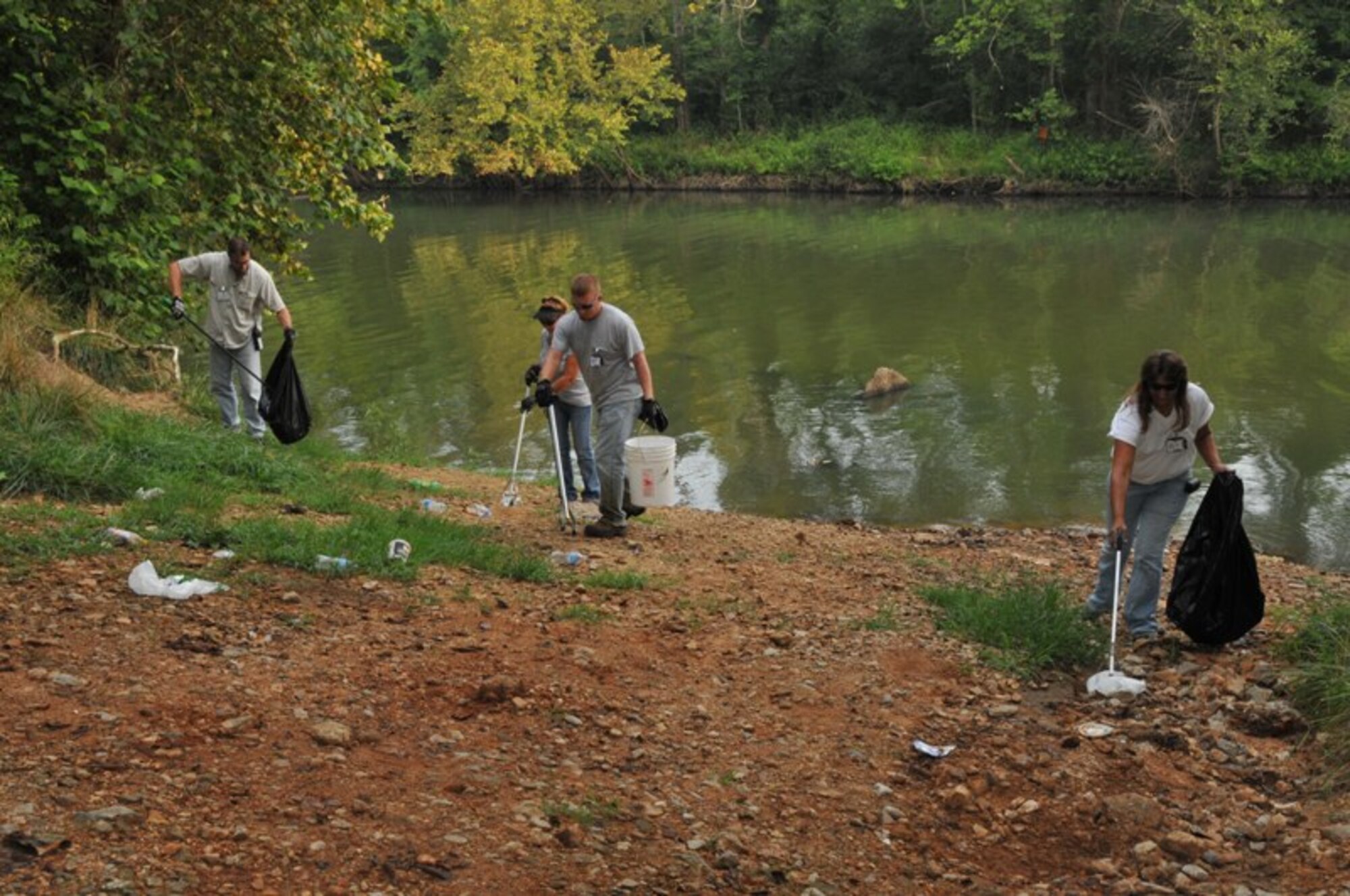 Left to right, John Wiesen, an Aerospace Testing Alliance (ATA) truck driver, and Donna Bottomlee, Jeff Brothers and Julie Melson, laborers also with ATA, pick up trash on Arnold AFB property near the Woods Reservoir dam. ATA is the support contractor for the base. (Photo by David Housch)