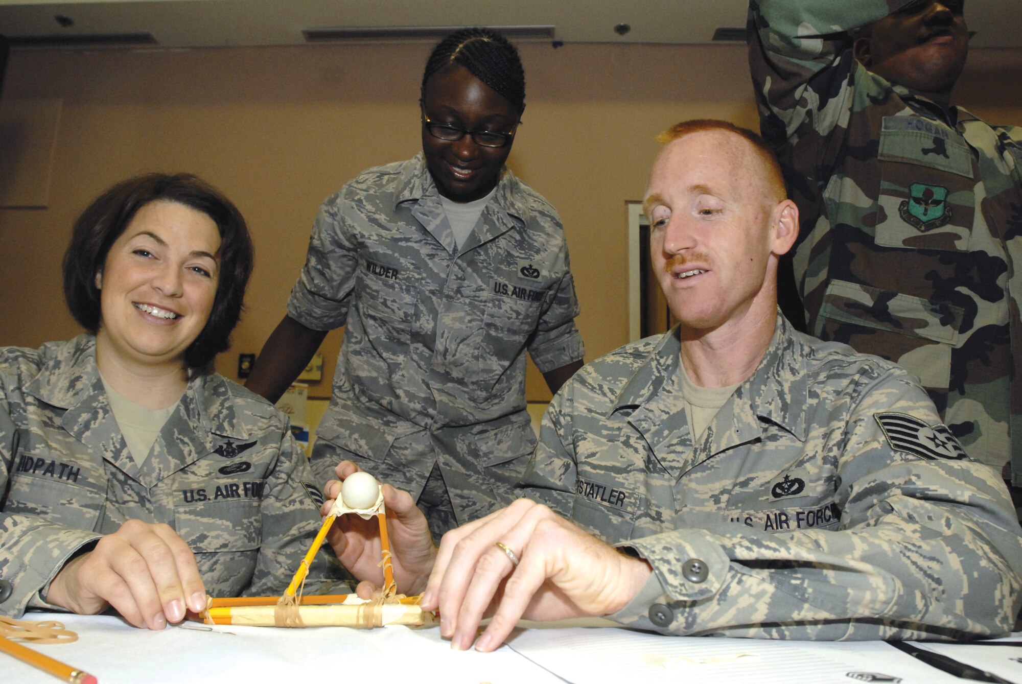 From left to right: Technical Sergeants Pamela Reidpath, Alicia Wilder and Richard Huffstatler prepare to launch a ping-pong ball during "Junkyard Wars," a team-building exercise at the Senior NCO Orientation Course August 5. (U.S. Air Force photo by Master Sgt. Randy Mallard)