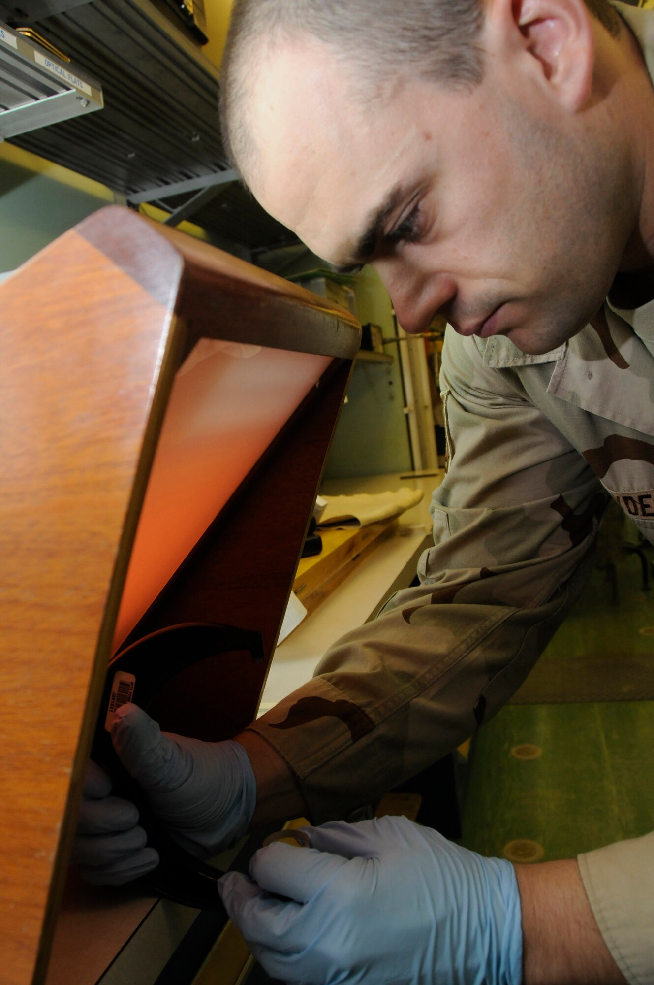 Tech. Sgt. Kevin Clyde calibrates the flatness of a micrometer spindle under a monochromatic light Aug. 4 using an optical flat. Sergeant Clyde is with the 379th Expeditionary Maintenance Squadron's Precision Measurement Equipment Laboratory at an air base in Southwest Asia.  He is deployed from Travis Air Force Base, Calif.  (U.S. Air Force photo/Staff Sgt. Darnell T. Cannady)