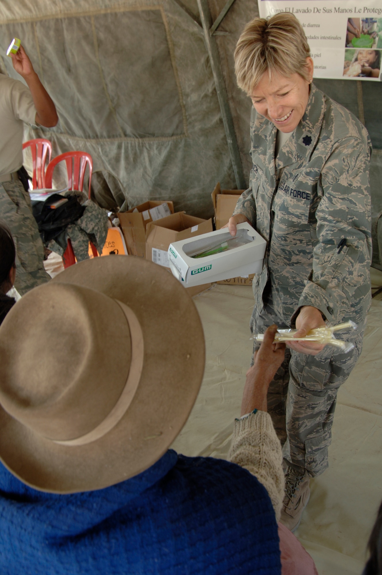Lt. Col. Helen Crouch, from the 433rd Medical Group at Lackland AFB, Texas, passes out toothbrushes to Peruvian people listening to a public health lecture, Aug. 1, during a medical mission in Mollepata, Peru.  A team of 19 medical personnel deployed to Ayacucho, Peru to support the final three of nine medical missions supporting New Horizons - Peru 2008, a U.S. and Peruvian effort to bring humanitarian aid to underpriviliged Peruvians. (U.S. Air Force photo/1st Lt. Mary Pekas)