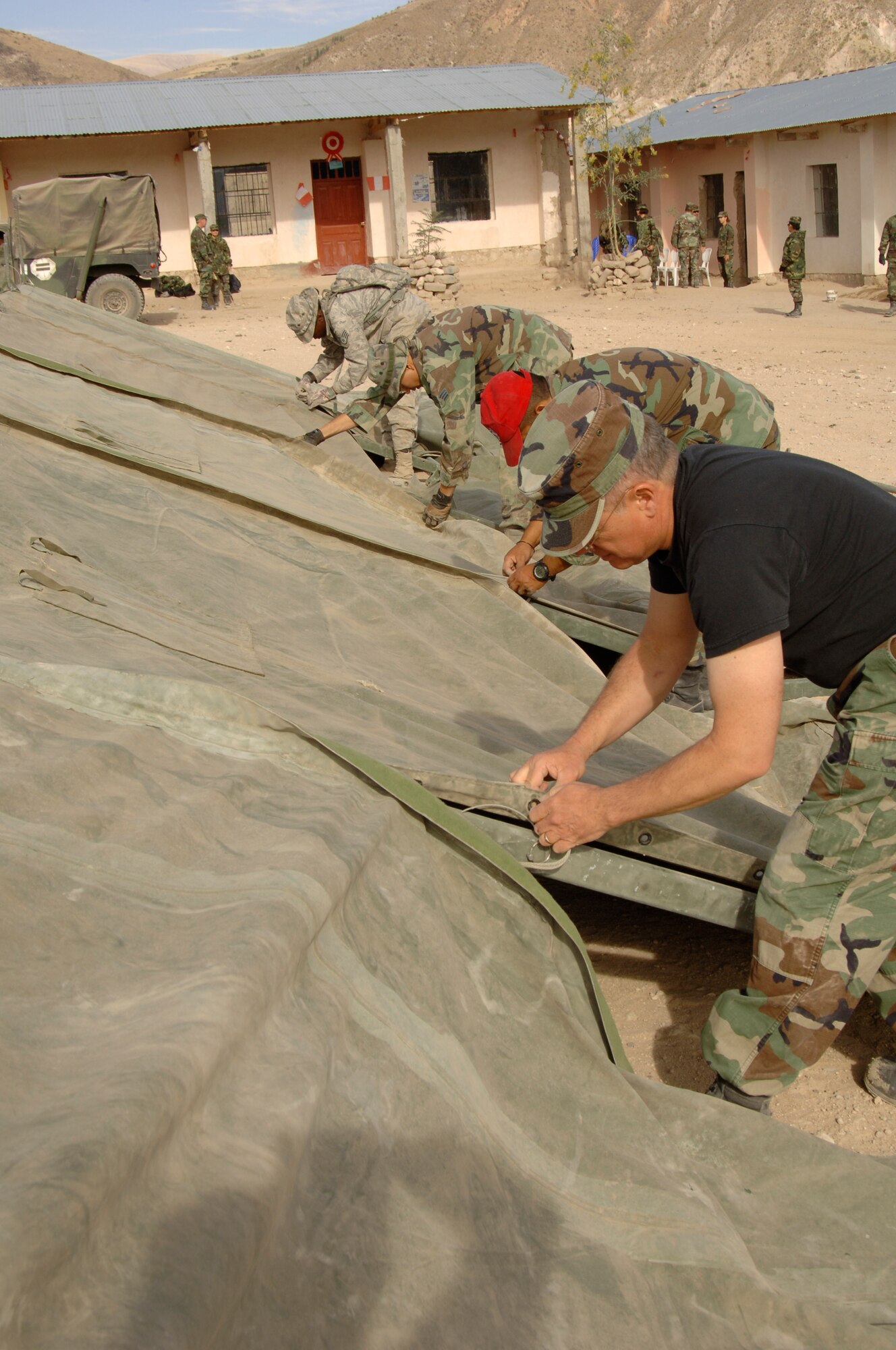 Members of Task Force New Horizons assemble a tent, Aug. 1, in preparation for a medical mission in Mollepata, Peru, supporting New Horizons - Peru 2008.  The humanitarian mission is a partnered effort between the U.S. and Peru to bring quality-of-life construction projects and medical missions to underiviliged Peruvians. (U.S. Air Force photo/1st Lt. Mary Pekas)