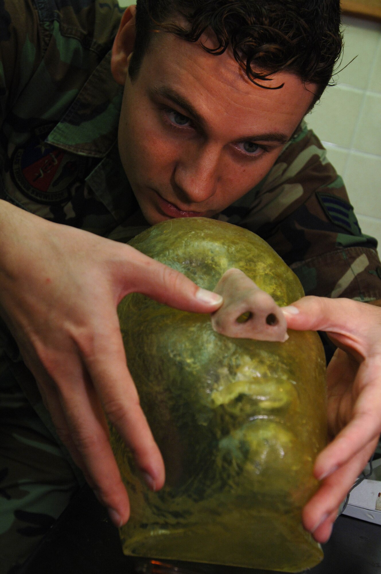 Maxillofacial prosthetic technician Senior Airman Justin Jones, 59th Dental Squadron, checks the fit and finish on a nose he is sculpting as part of a patient's reconstructive treatment. (U.S. Air Force photo/Staff Sgt. Erin Peterson)