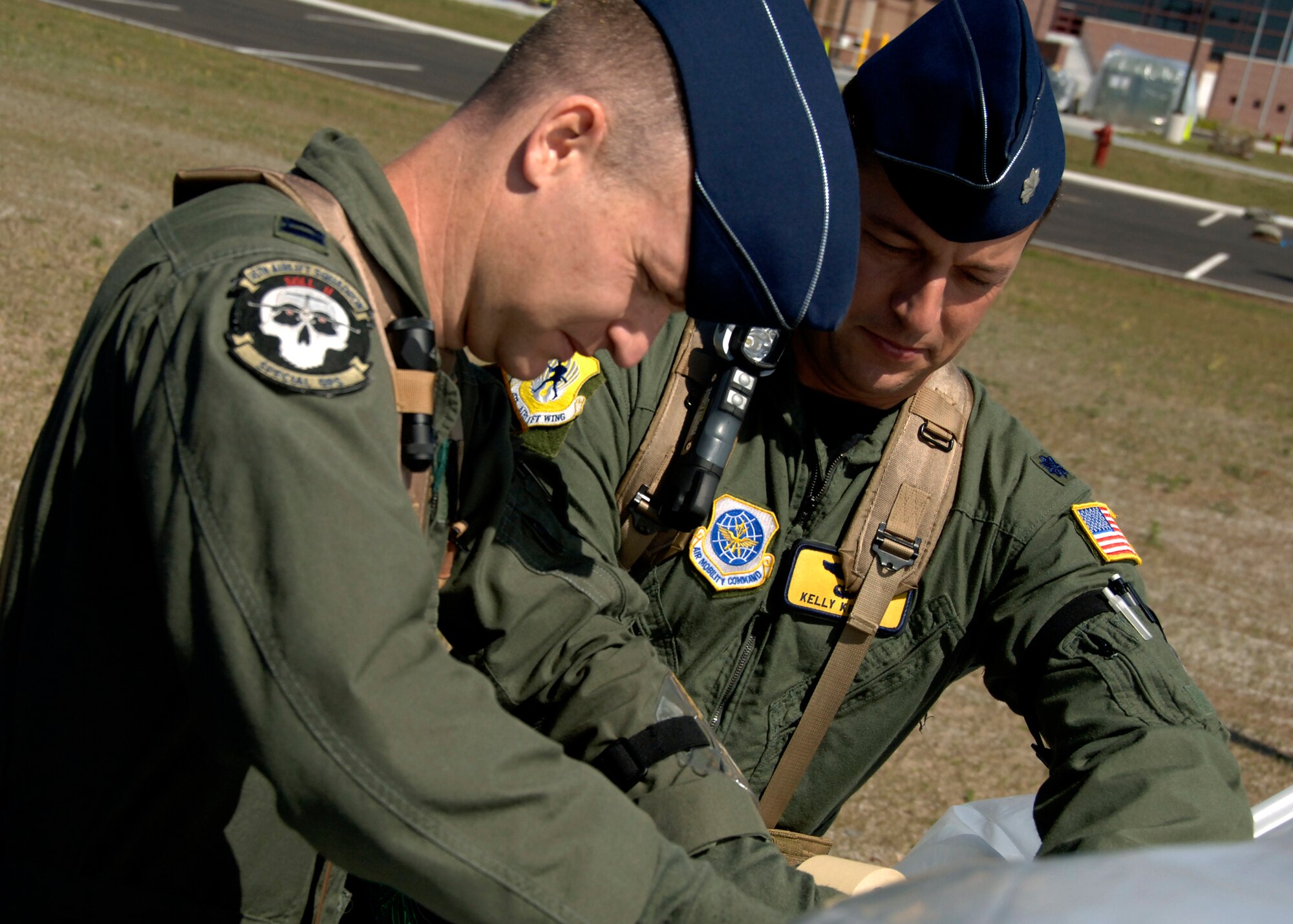 Capt. Chris Stephens (left) and Lt. Col. Kelly Kimsey cover a vehicle with two layers of plastic to prevent chemical contamination Aug. 6 at a simulated air base in Southeast Asia. Operational assets are covered to decrease the chance of contamination in a chemical environment. Captain Stephens is assigned to the 437th Operations Group and Colonel Kimsey is a member of the 437th Airlift Wing. (U.S. Air Force photo/Airman 1st Class Timothy Taylor)


