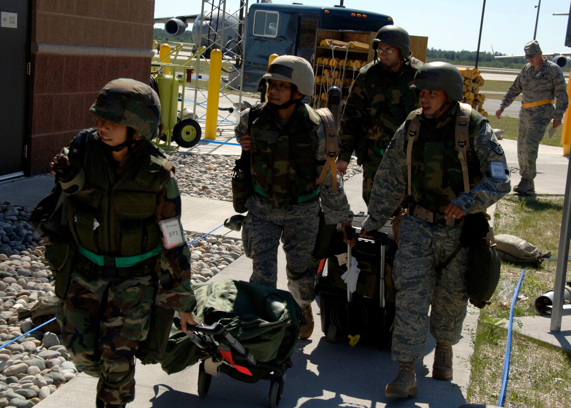 Airmen from 805th Expeditionary Logistics Readiness Squadron proceed to their alternate operations location after receiving a "bug-out" call at a simulated forward deployed location in Southeast Asia Aug. 6. "Bug-out" drills are conducted to demonstrate the effectiveness of building occupants to evacuate quickly from a primary work location to an alternate location as quickly and safely as possible.  (U.S. Air Force photo/Airman 1st Class Timothy Taylor)

