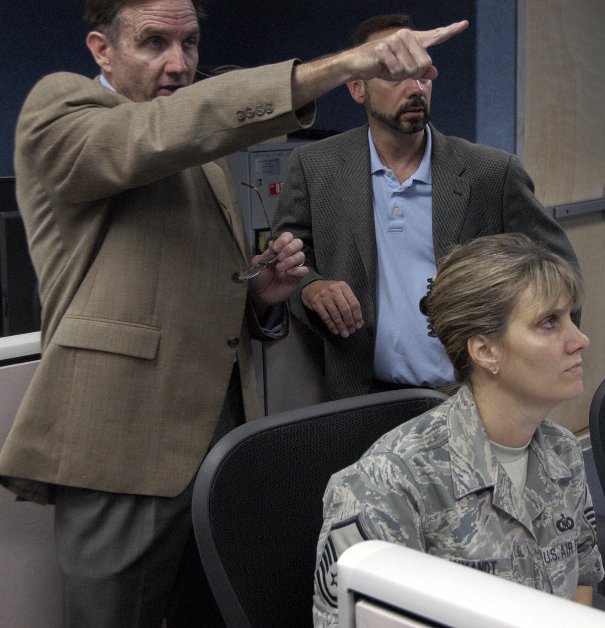 Mr. Larry Christie (forward) and Mr. Steve Boe of AFNORTH DMO team instruct Master Sgt. Angie Wyandt during a VIRTUAl FLAG scenario at Tyndall AFB.  The DMO team is competing fot the 2008 Chief of Staff Team Excellence Award.                                