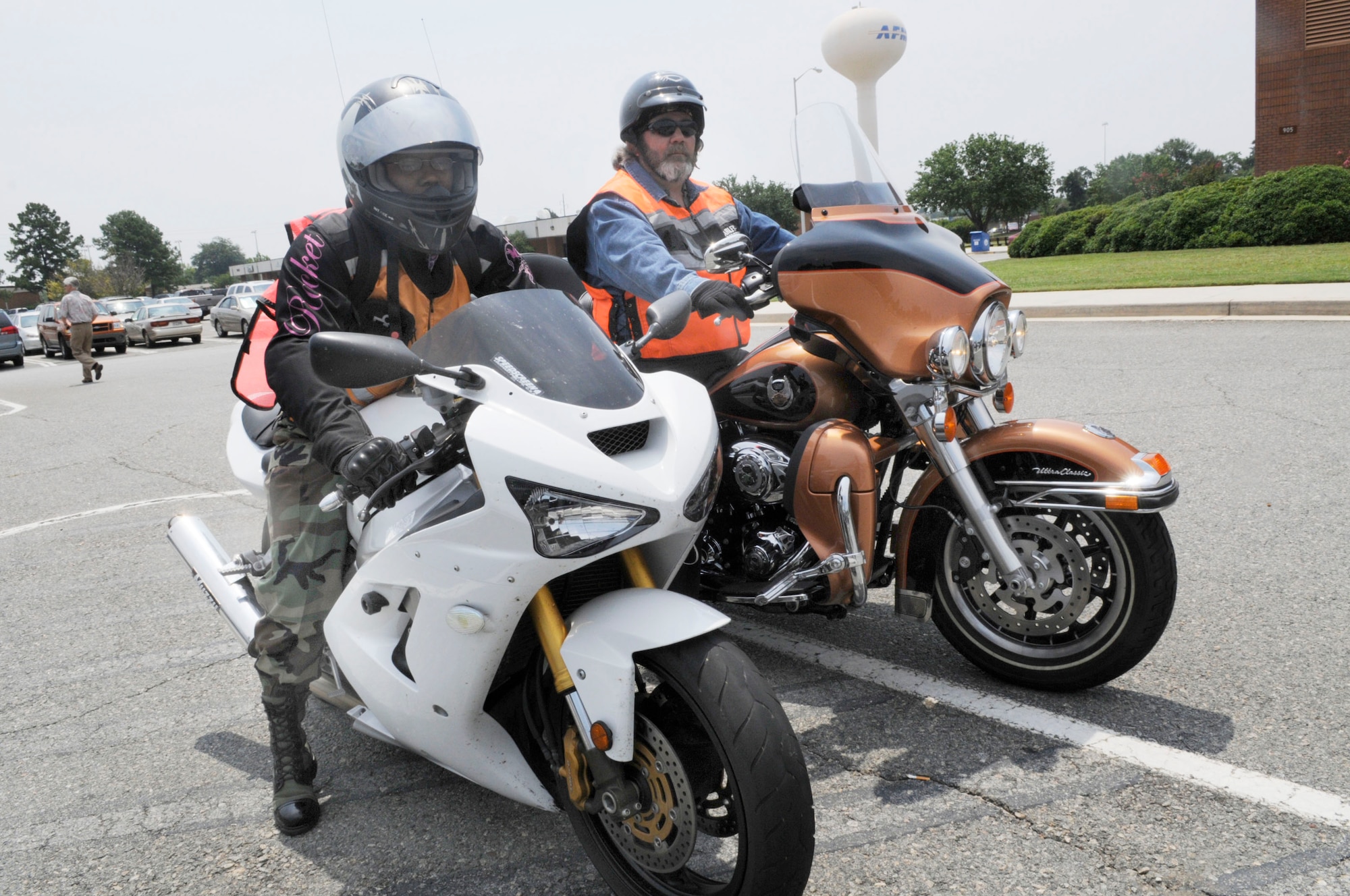 Staff Sgt. Adria "Dee" Edwards, with her Kawasaki Ninja 636, and William Haffner, with his Harley Davidson Ultra Classic Electra Glide, show the proper equipment for motorcycle riding. That equipment includes helmet, gloves, boots, long sleeves and pants,and a reflective vest. If the rider is carrying a backpack it should be reflective as well.  U.S. Air Force file photo by Sue Sapp 