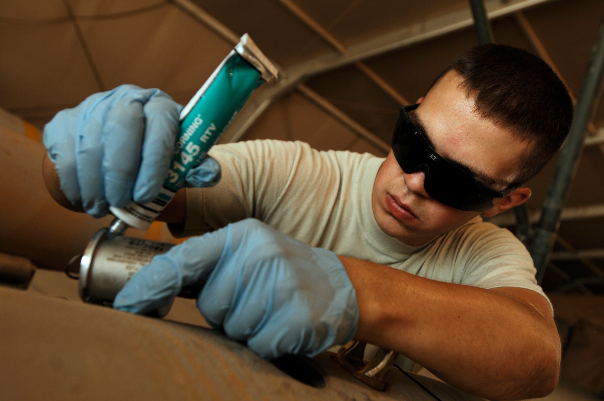 JOINT BASE BALAD, Iraq -- Airman 1st Class Troy Harlow applies sealant around the charging well of a GBU-38 Joint Direct Attack Munition here Aug. 7. Applying sealant prevents dust and water from entering the munition. Airman Harlow, a munitions handler with the 332nd Expeditionary Maintenance Squadron, is deployed from Hill Air Force Base, Utah. His hometown is Grand Forks, N.D. (U.S. Air Force photo/Airman 1st Class Jason Epley)