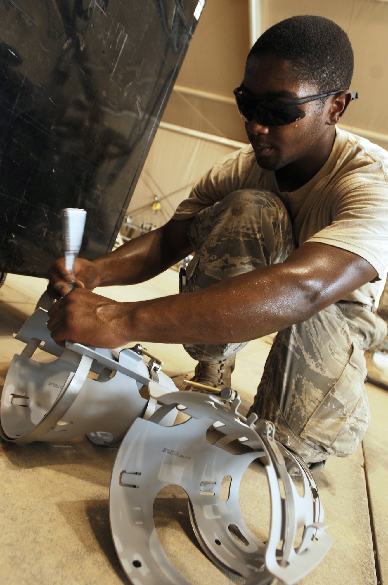 JOINT BASE BALAD, Iraq -- Airman 1st Class Antione Eaddy loosens a strake strap that will be assembled onto a GBU-38 Joint Direct Attack Munition here Aug. 7. The JDAM contains an inertial navigational system and a GPS guidance control unit that improves the accuracy of general purpose bombs in any weather condition. Airman Eaddy, a munitions handler with the 332nd Expeditionary Maintenance Squadron, is deployed from Shaw Air Force Base, S.C. His hometown is Detroit. (U.S. Air Force photo/Airman 1st Class Jason Epley)