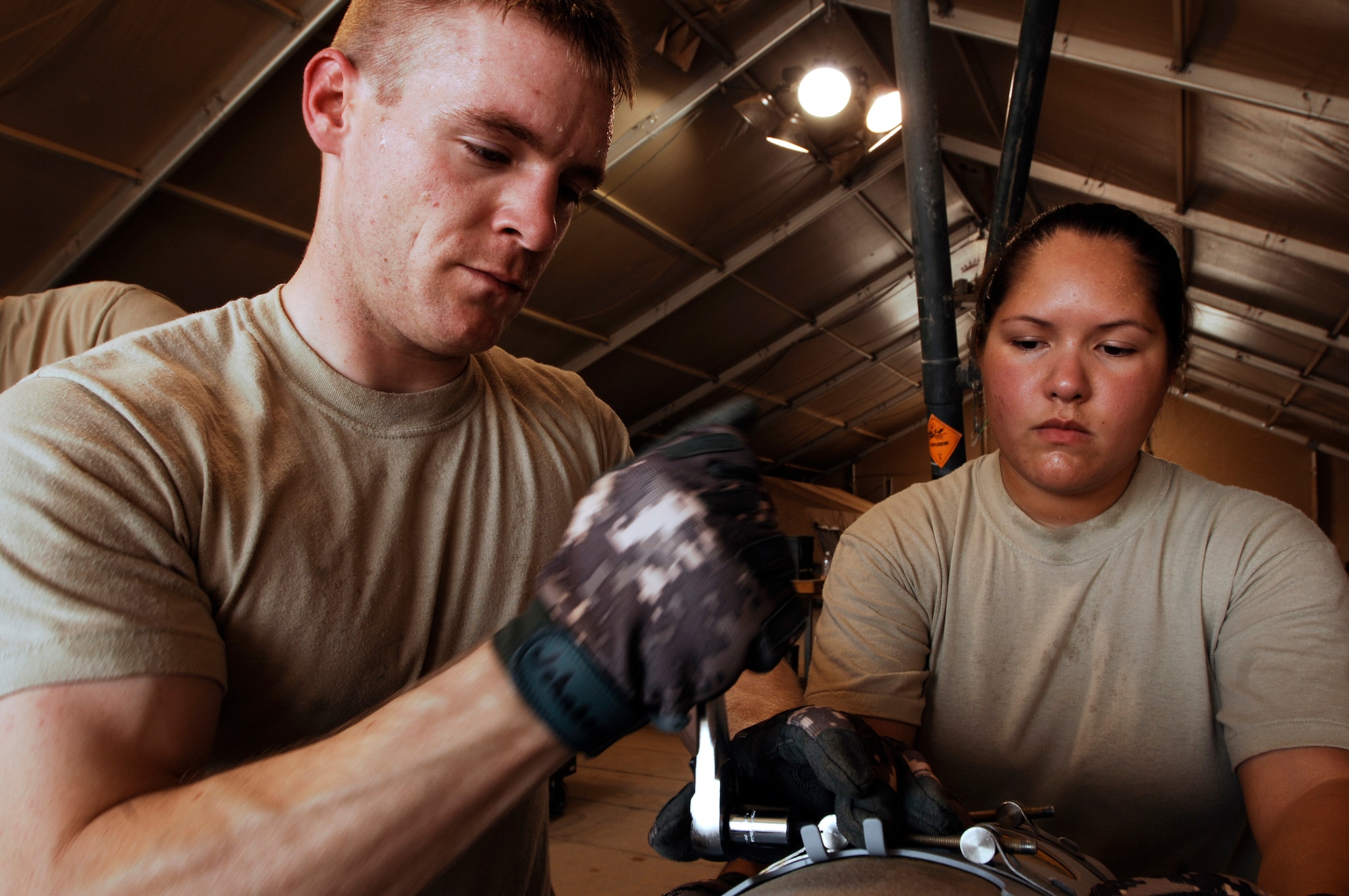 JOINT BASE BALAD, Iraq -- Senior Airman Gregorey Effler and Staff Sgt. Marissa Ferguson  install a strake assembly onto a GBU-38 Joint Direct Attack Munition here Aug. 7. The JDAM contains an inertial navigational system and a GPS guidance control unit that improves the accuracy of general purpose bombs in any weather condition. Sergeant Ferguson and Airman Effler, munitions handlers with the 332nd Expeditionary Maintenance Squadron, are deployed from Hill Air Force Base, Utah. Sergeant Ferguson?s hometown is Sacramento. Airman Effler is originally from Hammond, La. (U.S. Air Force photo/Airman 1st Class Jason Epley)