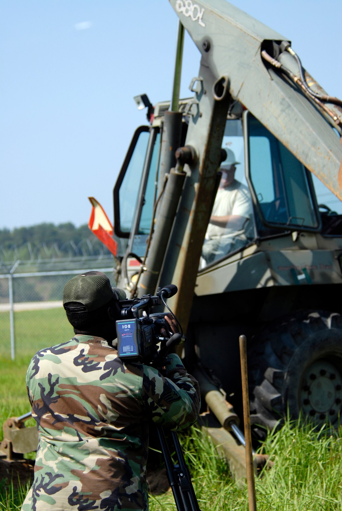 U.S. Air Force Staff. Sgt. Derick Spencer, 8 Fighter Wing Public Affairs Broadcaster, captures a back hoe operator digging trenches for communication wire on Kunsan Air Base, South Korea, 08 August 2008.  Faster communication allows leaders to be relayed up to the moment battle statistics, helping them make better decisions. (U.S. Air Force photo/Staff Sgt. Jason Colbert)