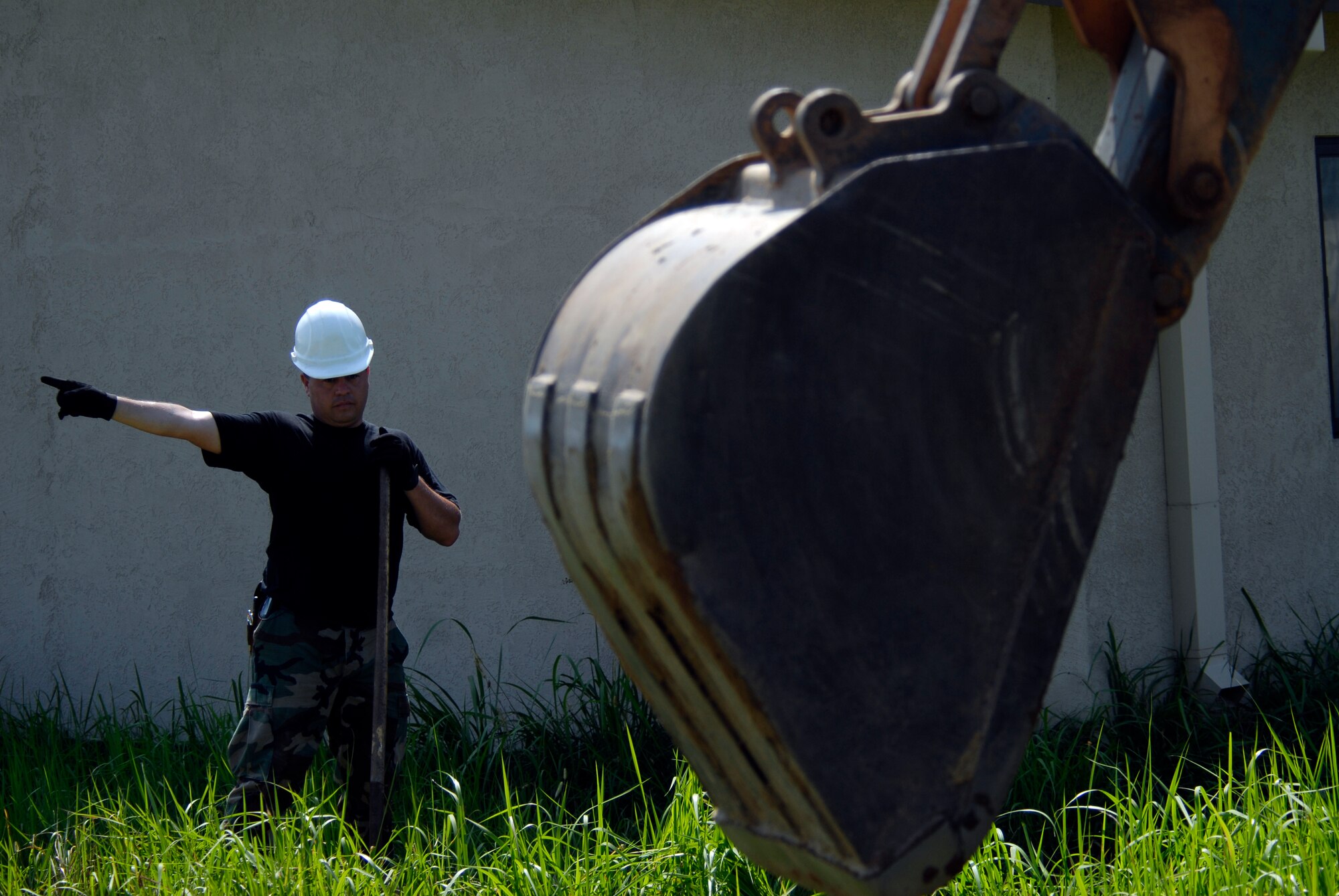 U.S. Air Force Staff Sgt. Alberto Martinez, 8th Communication Squadron Cable Technician, directs a back hoes where to dig its trench for communication wires on Kunsan AB, South Korea, 08 Aug 2008. Faster communication allows leaders to be relayed up to the moment battle statistics, helping them make better decisions. (U.S. Air Force photo/Staff Sgt. Jason Colbert)