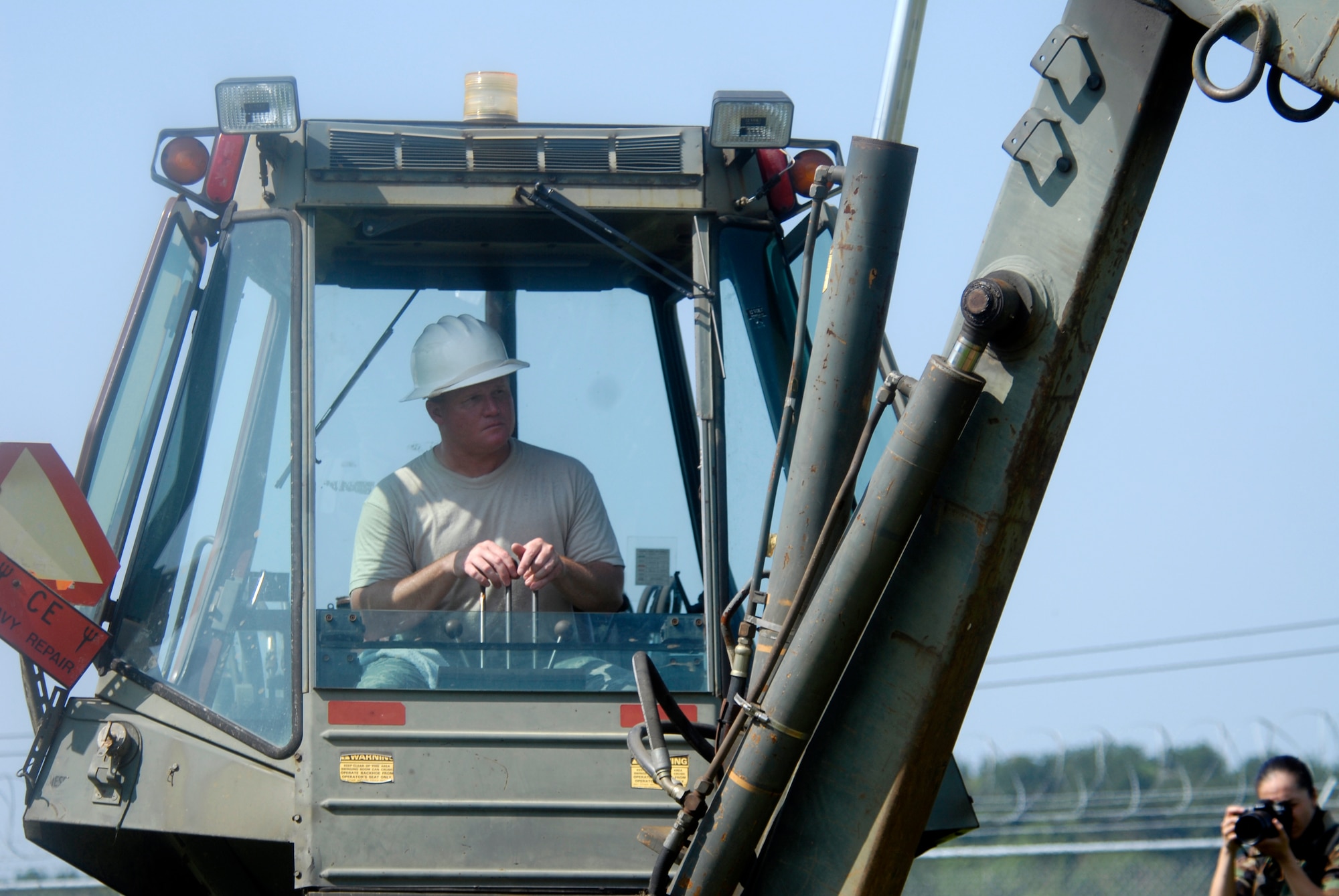 U.S. Air Force Tech. Sgt. Richard Thompson, 8th Communication Squadron Cable Technician, pilots a back hoes while digging trenches for communication cable that will be laid to enable faster communication with the F-16 pilots assigned to Kunsan AB, South Korea, 08 Aug 2008.  Faster communication allows leaders to be relayed up to the moment battle statistics, helping them make better decisions. (U.S. Air Force photo/Staff Sgt. Jason Colbert)